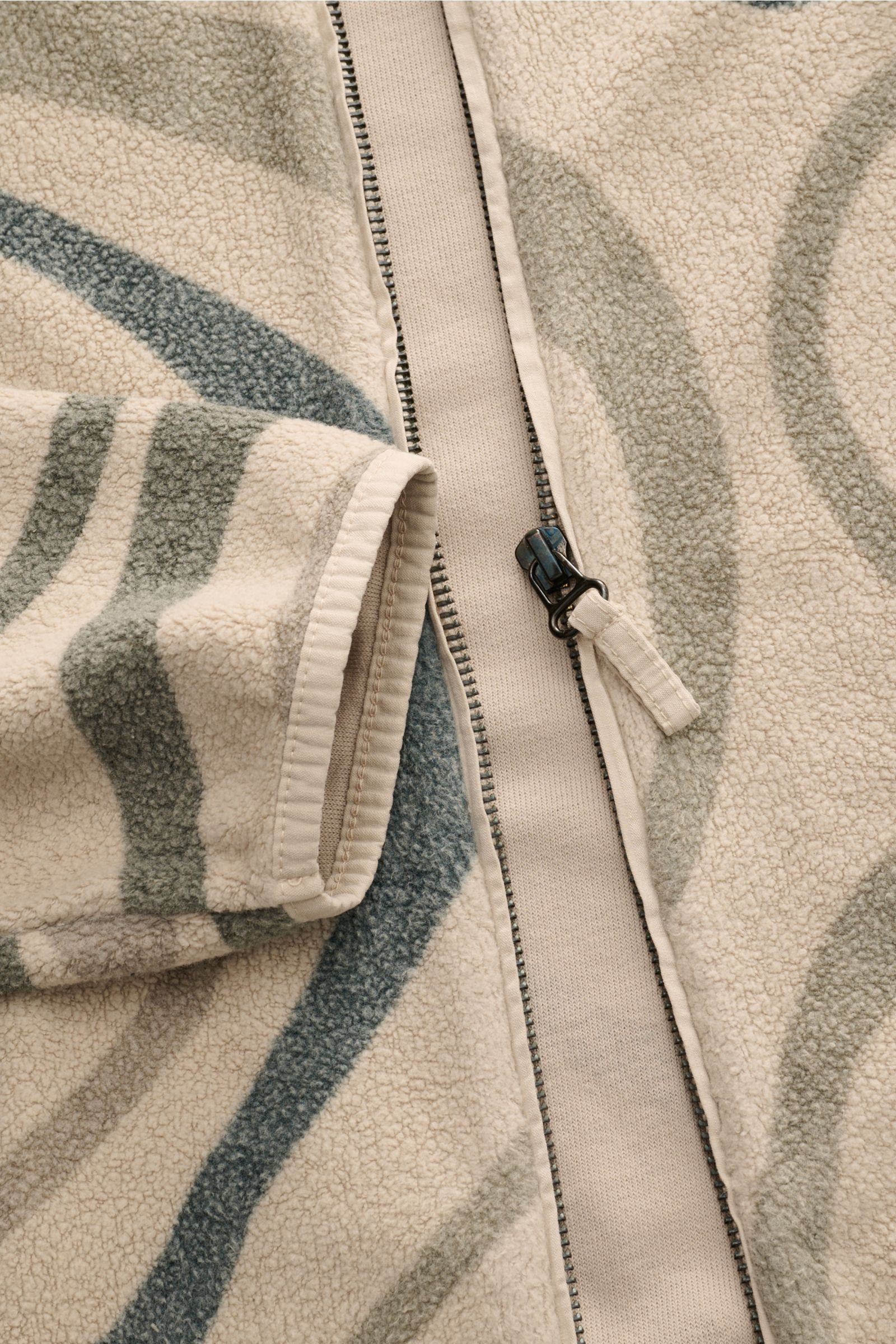 Close-up front view of 04651/ A trip in a bag Fleece-Blouson schwarz showing fleece aus reiner Baumwolle, weicher Griff, slim fit, Druckknopfleiste, typischer Blousonkragen aus Rippstrick, schräge Hüfttaschen, komfortable Rippbündchen, and Weblabel in der