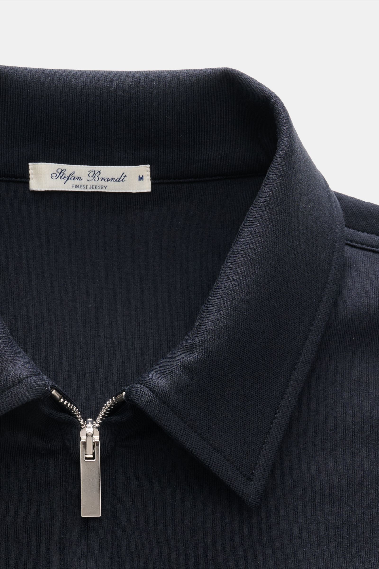 Close-up front view of Stefan Brandt Sweatjacke 'Alek' navy, showing a silver two-way zipper and folded collar in soft Pima cotton.

Spürbarer Komfort auf höchstem Niveau: Selbst ein Essential wie die Sweatjacke 'Alek' wird bei 