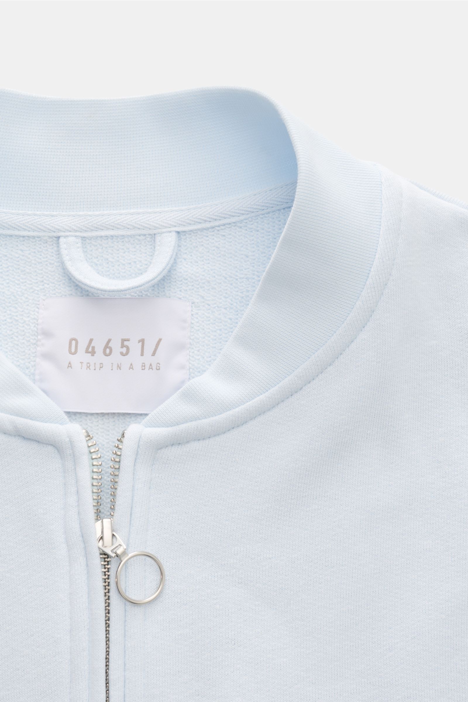 04651/ A trip in a bag Sweatjacke 'CL Bomber' pastellblau, Nahaufnahme von Kragen und robustem Zwei-Wege-Reißverschluss, soft, garment-dyed aus Bio-Baumwolle und Leinen.