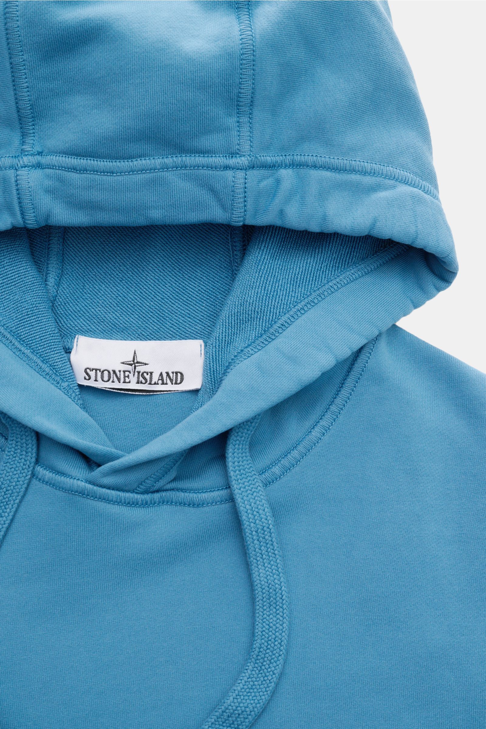 Stone Island Kapuzenpullover blau, Nahaufnahme von oben, Sweat aus Baumwolle, weicher Griff, garment dyed, Regular Fit, Overlock-Nähte, Kapuze mit Tunnelzug.