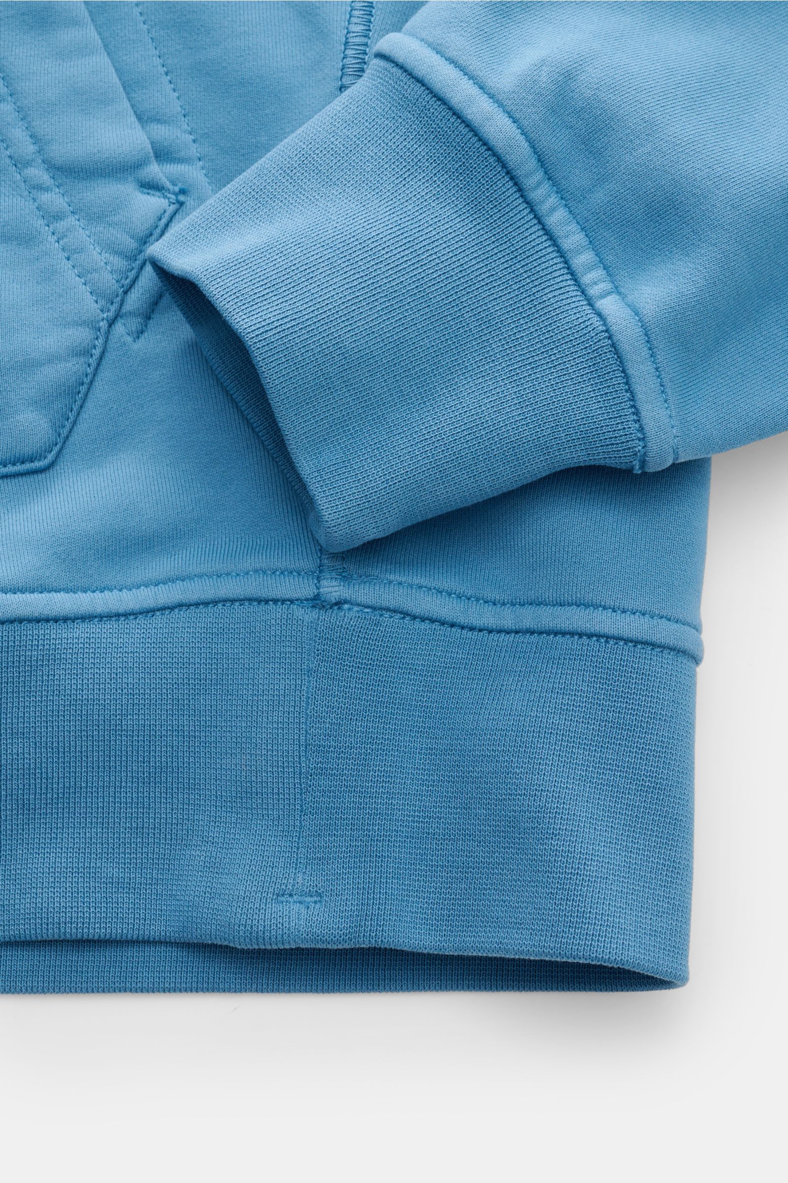 Stone Island Kapuzenpullover blau im Close-up von unten, Sweat aus reiner Baumwolle, weicher Griff, garment dyed, Regular Fit, markante Overlock-Nähte, Kängurutasche, Rippbündchen.