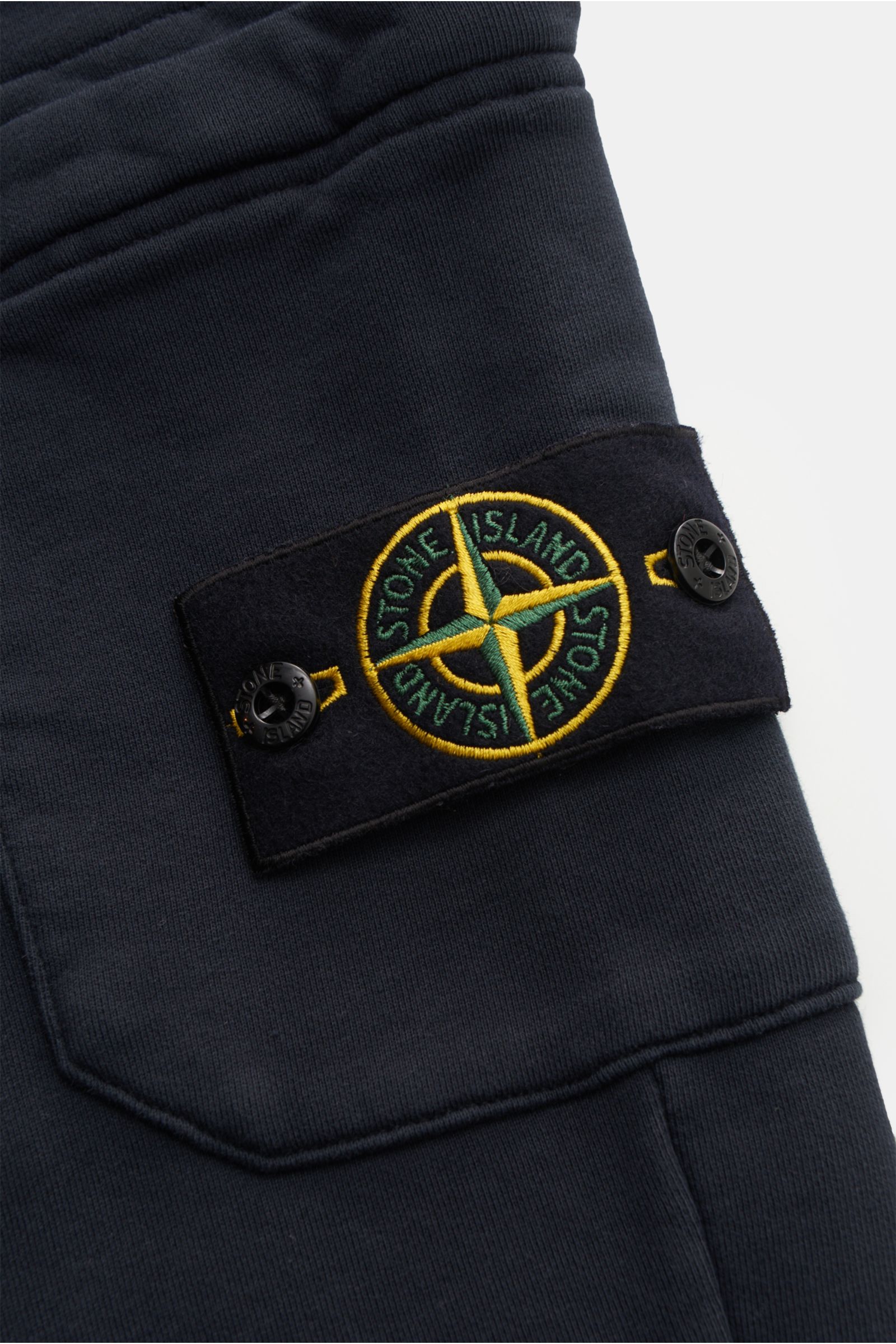 Stone Island Cargo-Sweathose 'Felpa' navy im Detail von nah, zeigt Cargo-Tasche mit Kompass-Badge, reine Baumwolle, elastischer Bund, Rippbündchen.