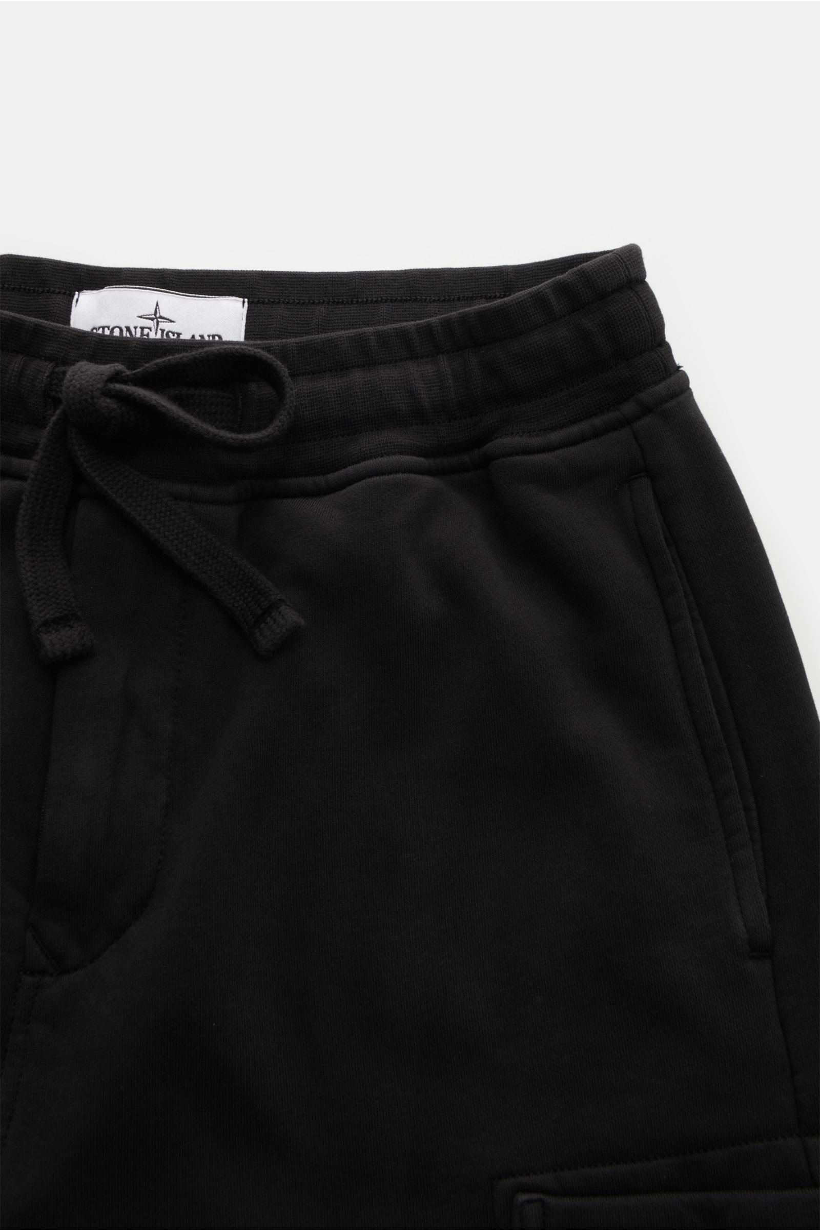 Stone Island Cargo-Sweatpants schwarz, frontale Nahaufnahme, elastischer Bund mit Tunnelzug, Nahttaschen, Cargo-Tasche, weicher Baumwoll-Sweat, schmal zulaufend, Kompass-Badge.
