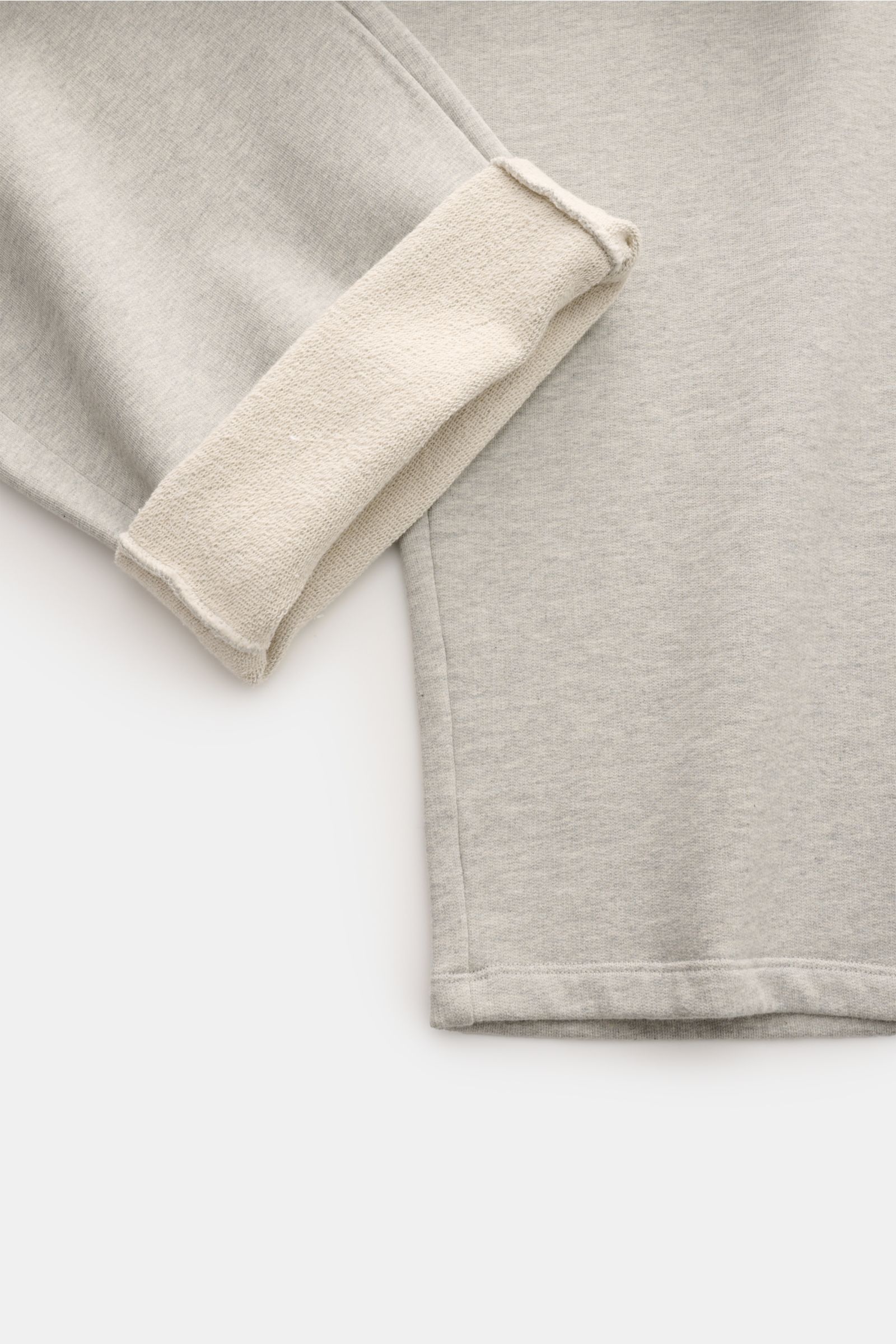 Ami Paris Sweathose 'Quota' grau meliert close-up from the side showing the soft, elastic cotton fabric with a folded cuff revealing the inner texture, highlighting the regular fit and clean silhouette. 

Komfort trifft auf Pariser Lässigkeit: Die 'Quo