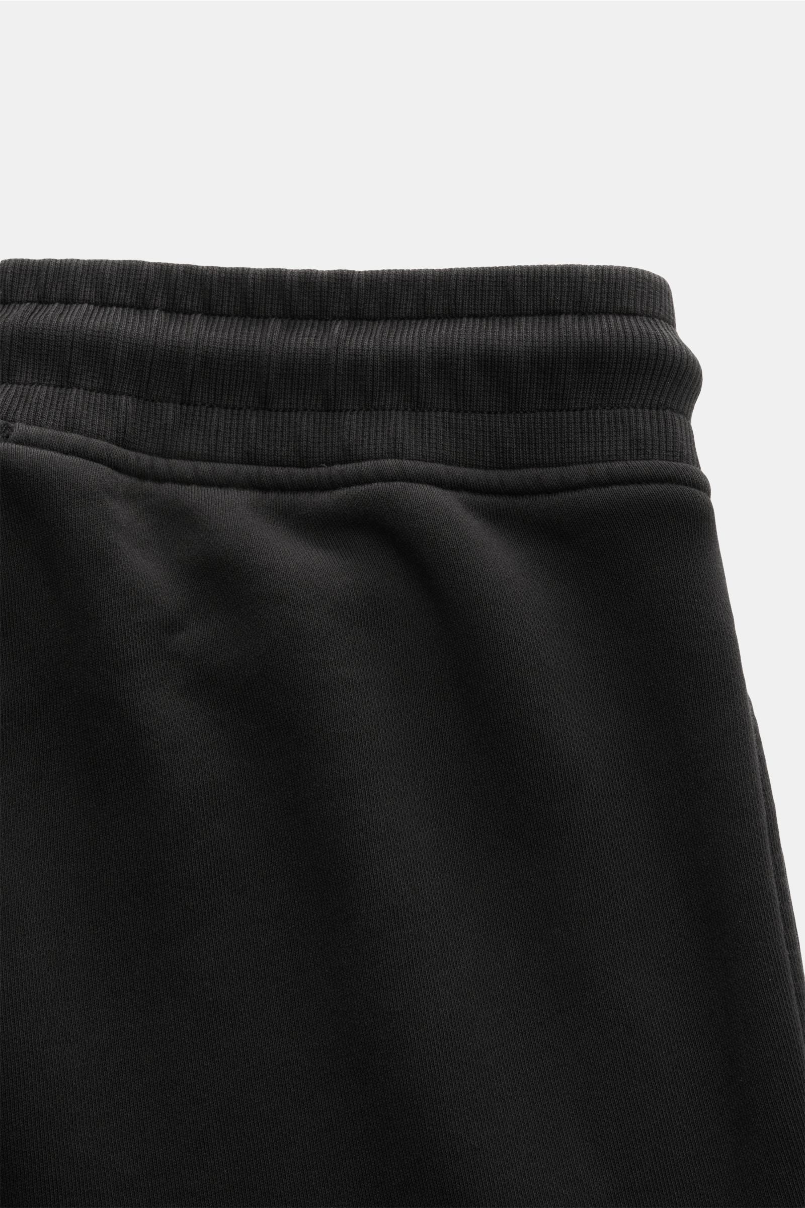 C.P. Company Cargo-Sweathose schwarz aus Baumwolle, slim Fit, elastischer Bund mit Tunnelzug, Cargo-Tasche, Rippbündchen, Nahaufnahme vom Bund.