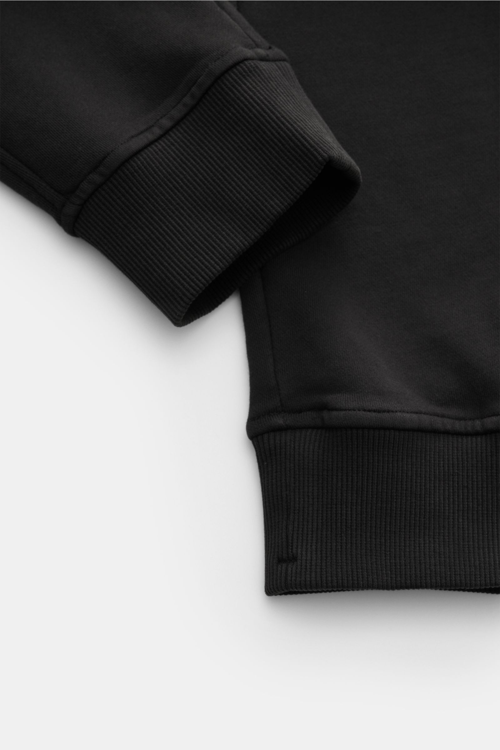 Nahaufnahme der Beinabschlüsse mit Rippbündchen der slim fit C.P. Company Cargo-Sweathose schwarz aus weicher Baumwolle.