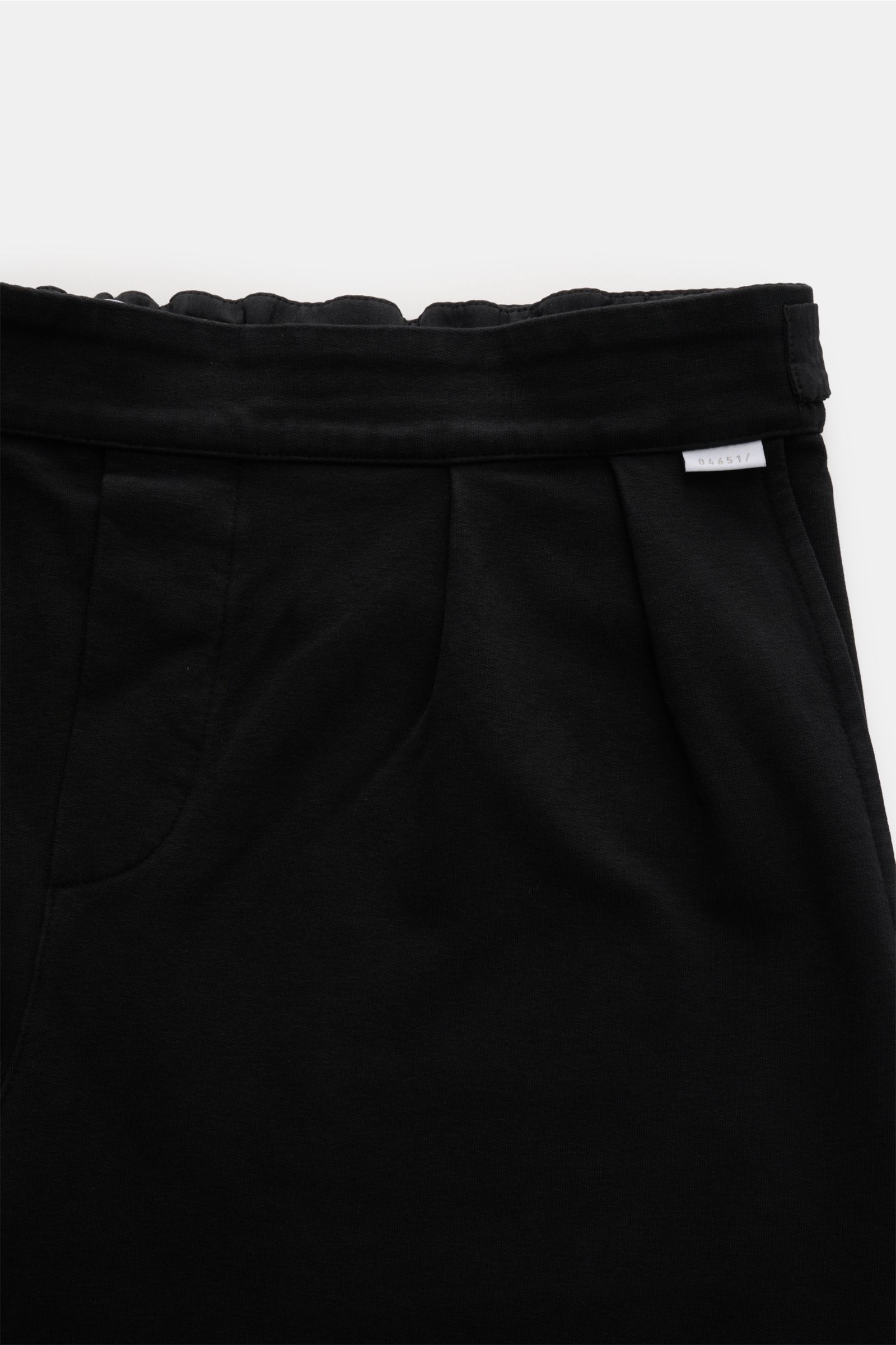 Close-up front view of 04651/ A trip in a bag Cotton trousers black, made of soft cotton jersey with double pleats and side adjusters for a classic look. Enjoy maximum comfort in your everyday life: These comfortable trousers from 04651/ A TRIP IN A BAG a