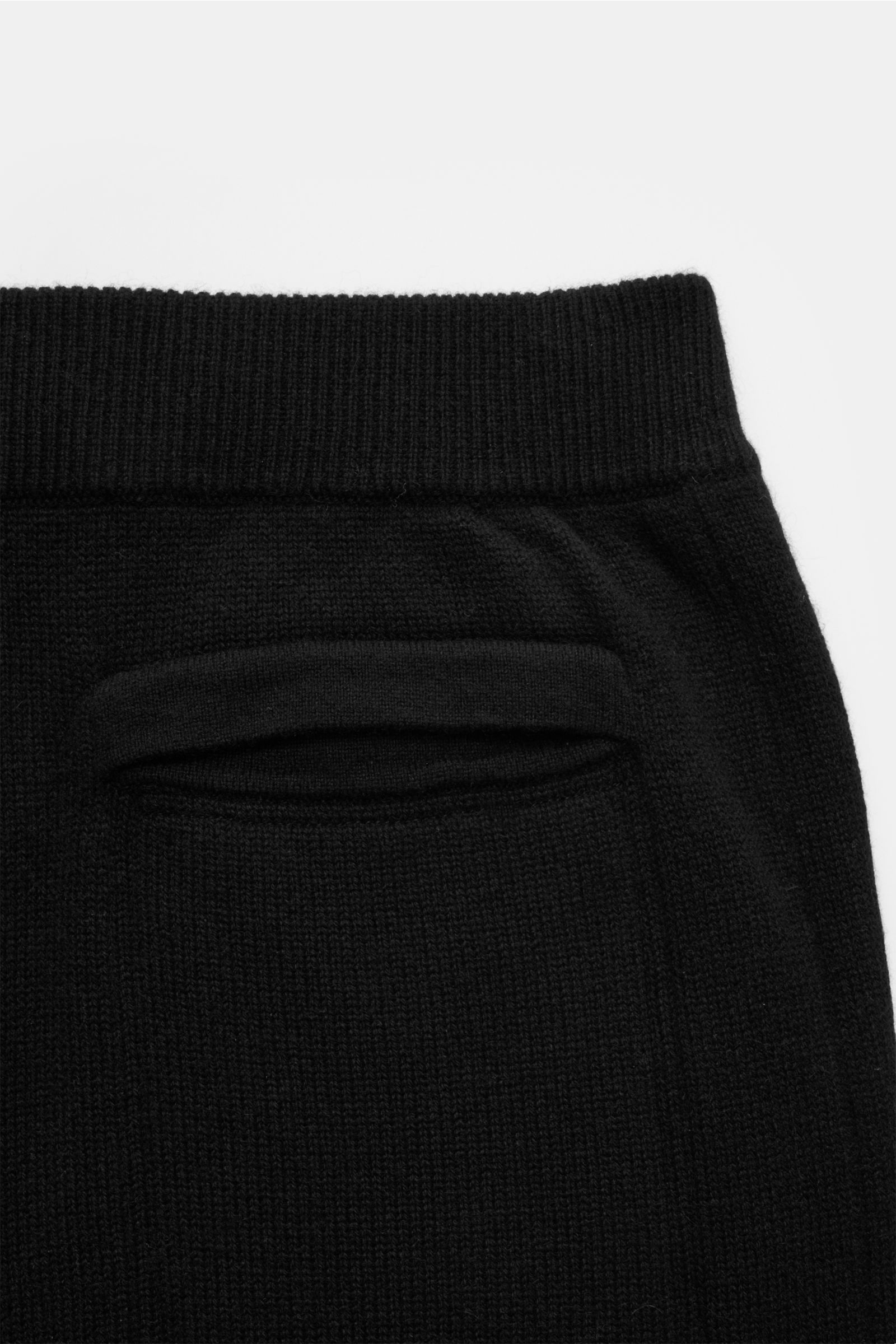 Von oben fotografierte von Braun Cashmere Jogpants schwarz mit elastischem Bund, angedeutetem Eingriff, Leistentasche und schräger Hüfttasche.