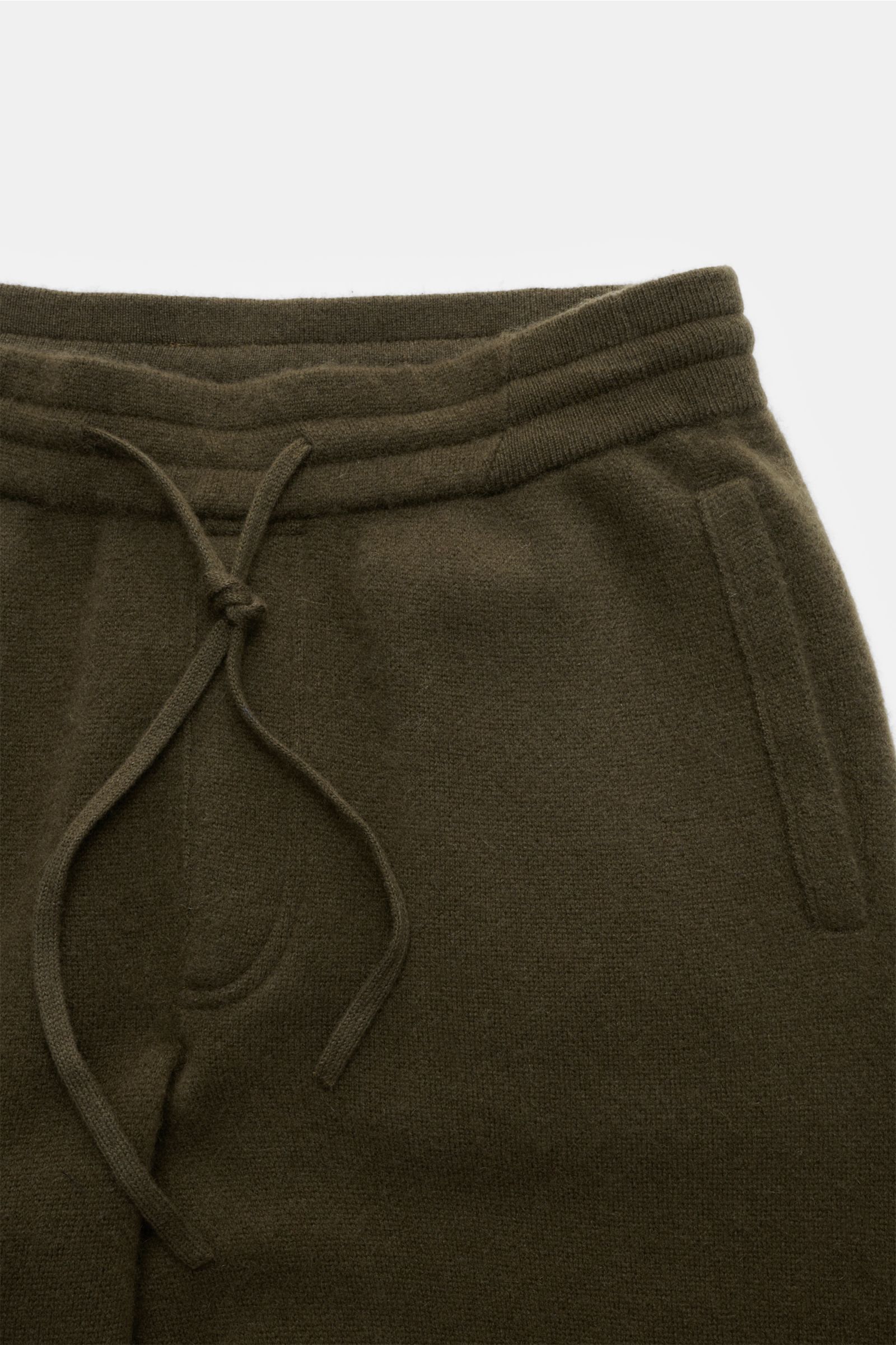 Nahaufnahme der von Braun Cashmere Jogpants dark olive aus feinem, weichem Cashmere mit elastischem Bund, Tunnelzug und schrägen Hüfttaschen.