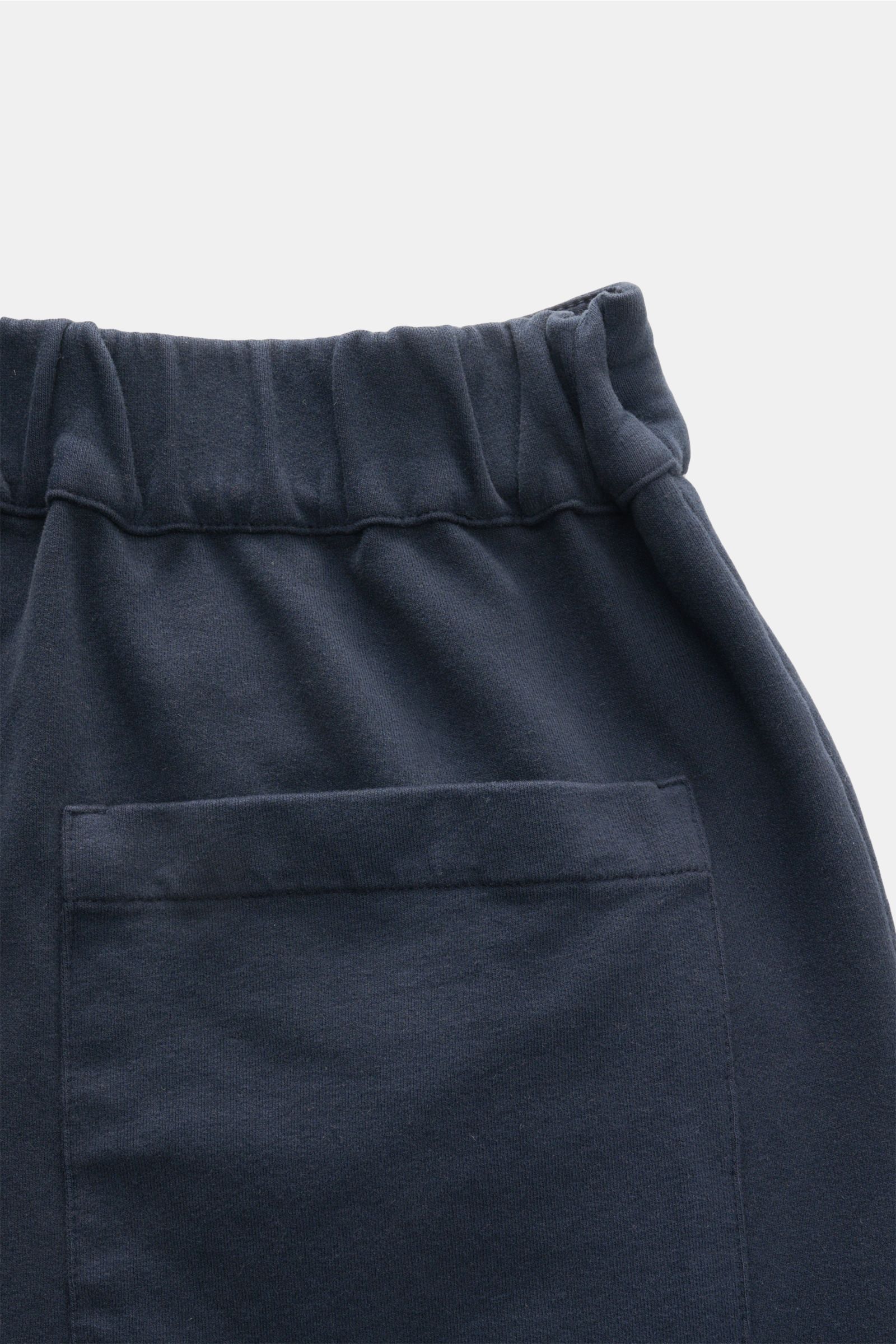 Close-up rear view of the waistband and back patch pocket of 04651/ A trip in a bag Jogger pants 'If' navy in soft cotton jersey.

Comfort meets style: These jogger pants in soft cotton jersey by 04651/ A TRIP IN A BAG enhance relaxed looks with a mode