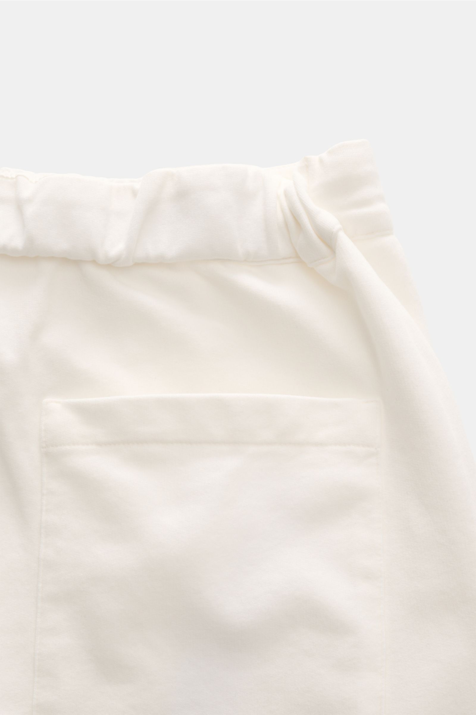 Close-up from above of the waistband and back pocket of 04651/ A trip in a bag Jogger pants 'If' off-white in soft cotton jersey with elastic drawstring waist.