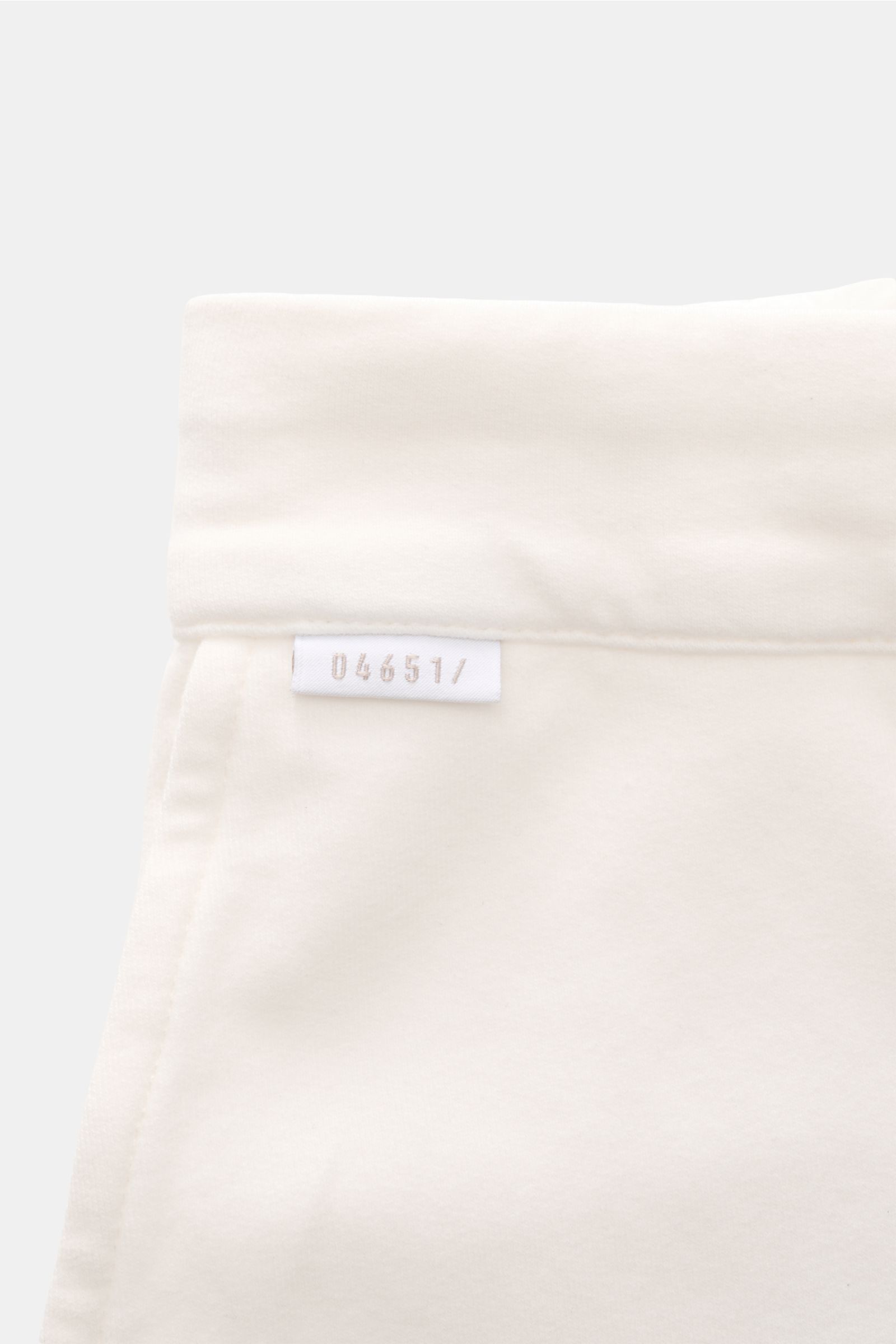 Close-up front view of the waistband and label of 04651/ A trip in a bag Jogger pants 'If' off-white in soft cotton jersey.

Comfort meets style: These jogger pants in soft cotton jersey by 04651/ A TRIP IN A BAG enhance relaxed looks with a modern sil