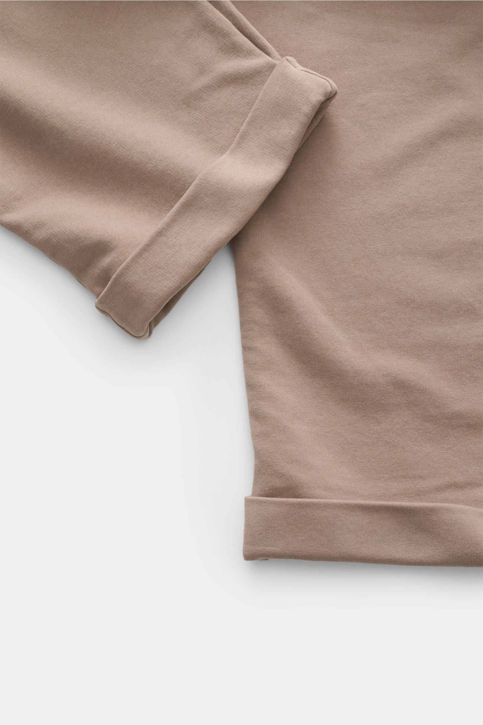 Close-up top view of folded cuffs and fabric texture of 04651/ A trip in a bag Jogger pants 'If' taupe in soft cotton jersey. Comfort meets style: These jogger pants in soft cotton jersey by 04651/ A TRIP IN A BAG enhance relaxed looks with a modern silho