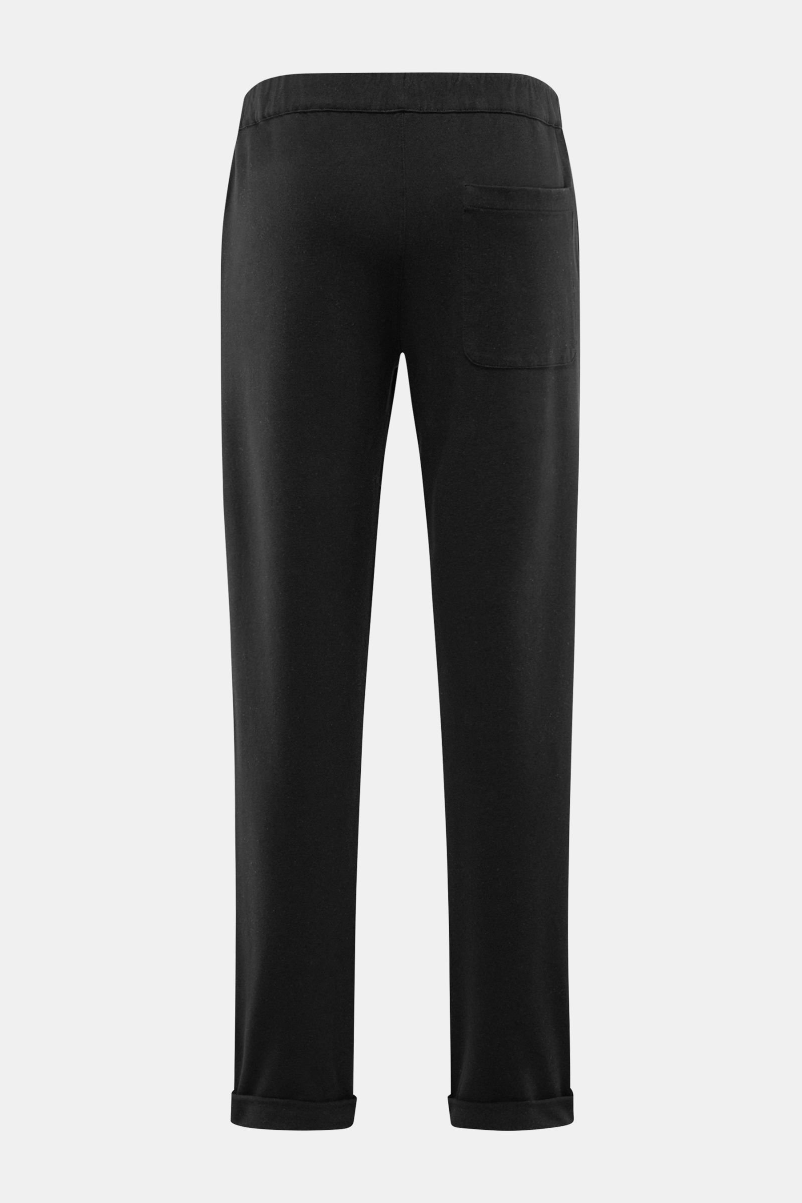 Black jogger pants shown from the back in a straight-on view. 04651/ A trip in a bag Jogger pants 'If' black in soft cotton jersey with comfortable stretch, soft feel, tapered fit, regular thigh width, ankle length, tapered cut, partially elasticated wais