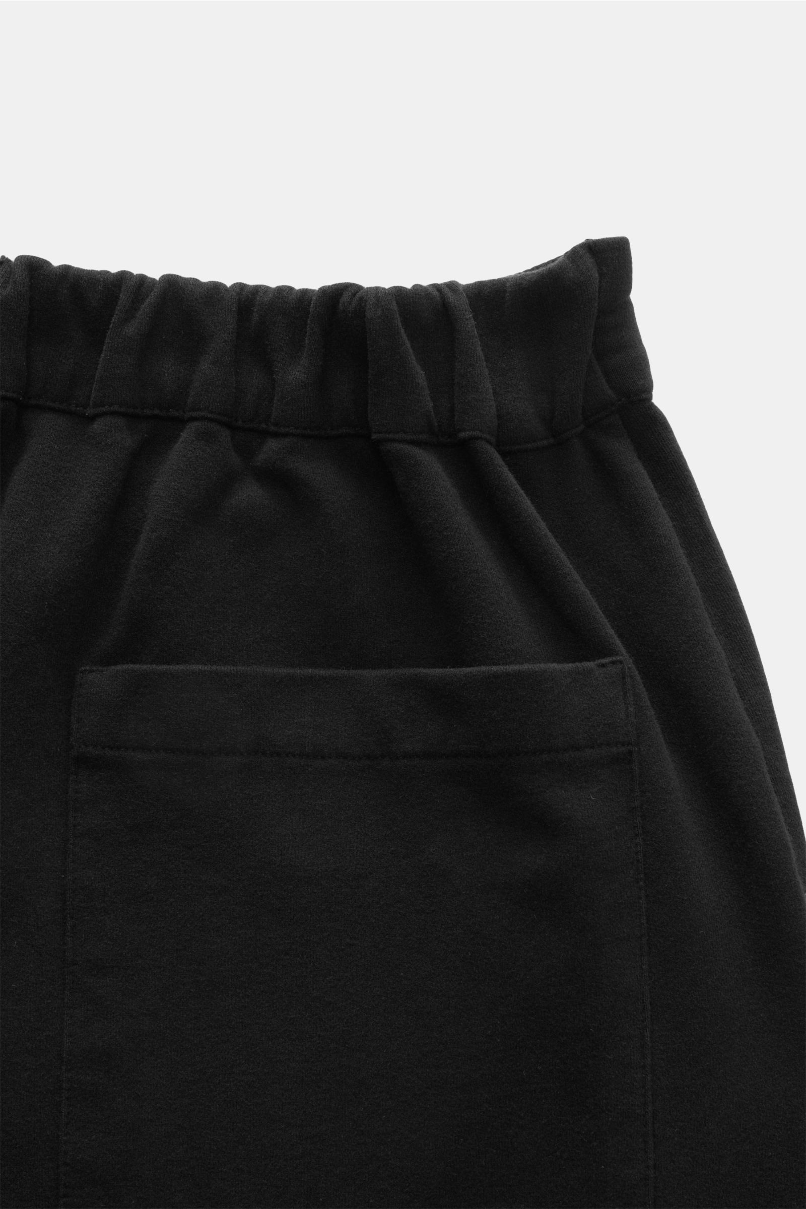 Close-up rear view of 04651/ A trip in a bag Jogger pants 'If' black showing elastic waistband and patch back pocket in soft cotton jersey.

Comfort meets style: These jogger pants in soft cotton jersey by 04651/ A TRIP IN A BAG enhance relaxed looks w