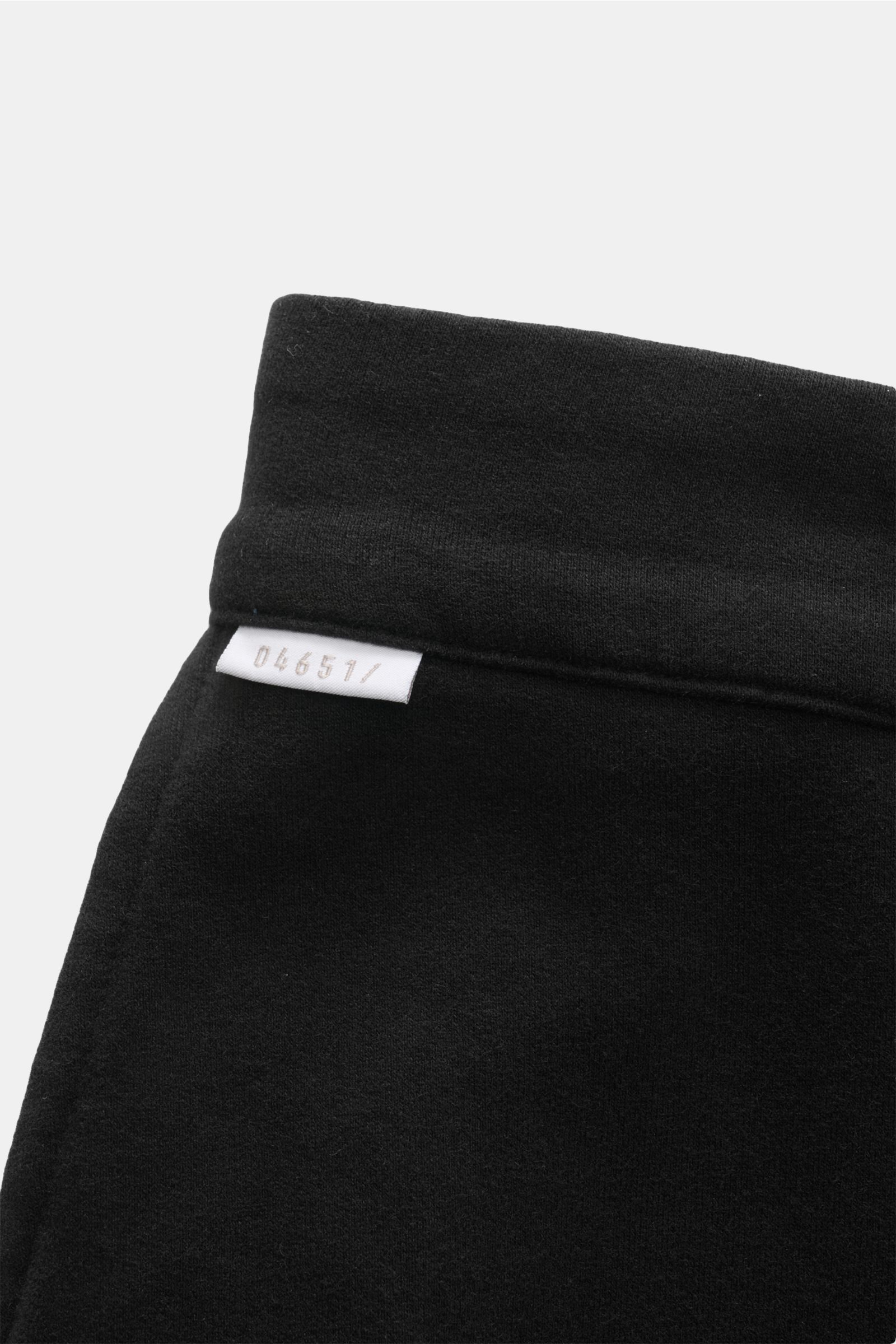 Close-up view of the black waistband with white 04651/ label on the 04651/ A trip in a bag Jogger pants 'If' black in soft cotton jersey.

Description: Comfort meets style: These jogger pants in soft cotton jersey by 04651/ A TRIP IN A BAG enhance rela