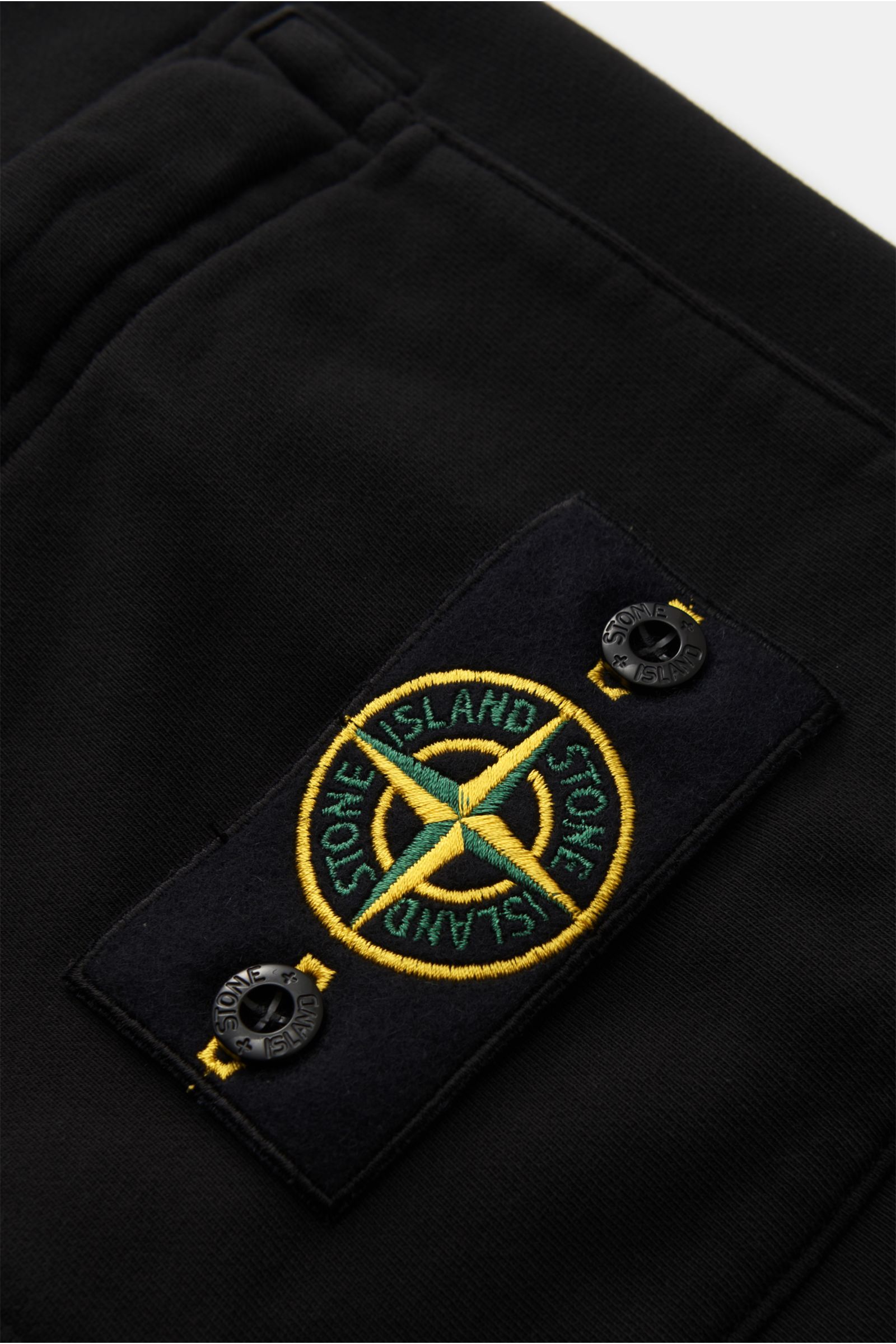 Nahaufnahme der schwarzen Stone Island Cargo-Sweatshorts 'Felpa' mit elastischem Bund und gut sichtbarem Kompass-Badge auf der Cargotasche aus weichem Baumwoll-Sweat.