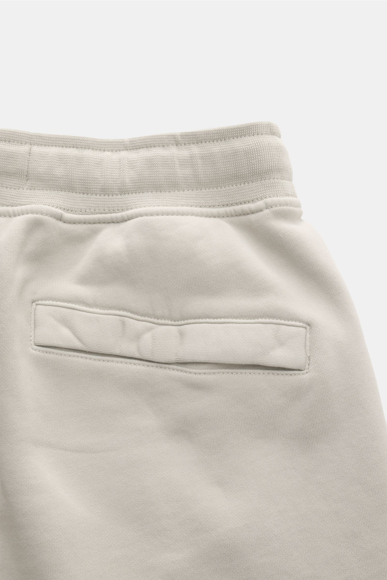 Nahaufnahme der hellgrauen Stone Island Sweatshorts 'Felpa Bermuda' von hinten, mit elastischem Bund, Gesäßtasche mit Druckknopf und weichem Baumwollstoff.