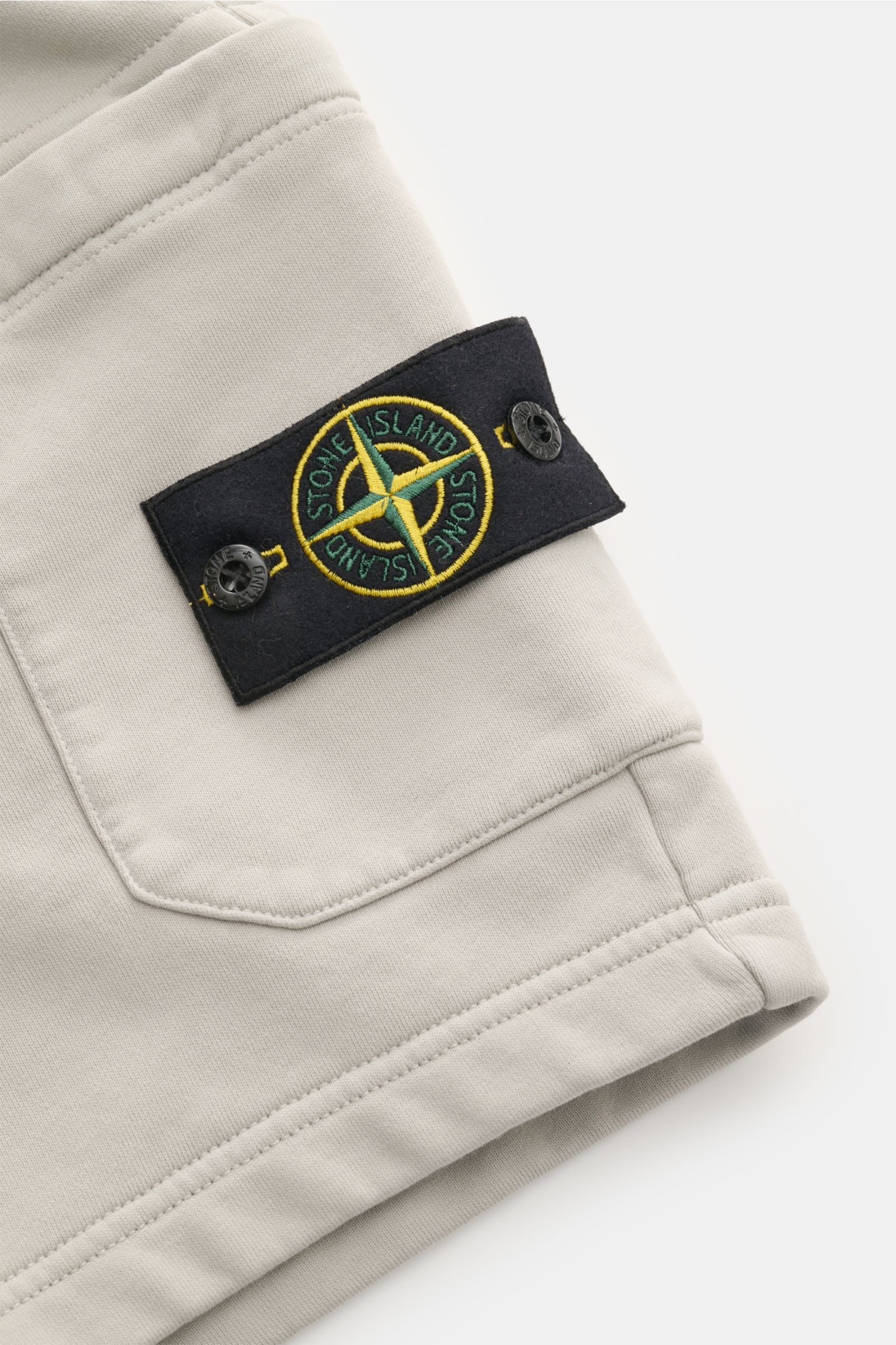 Stone Island Sweatshorts 'Felpa Bermuda' hellgrau, Detailansicht Cargo-Tasche mit Kompass-Badge aus reiner Baumwolle, elastischer Bund.