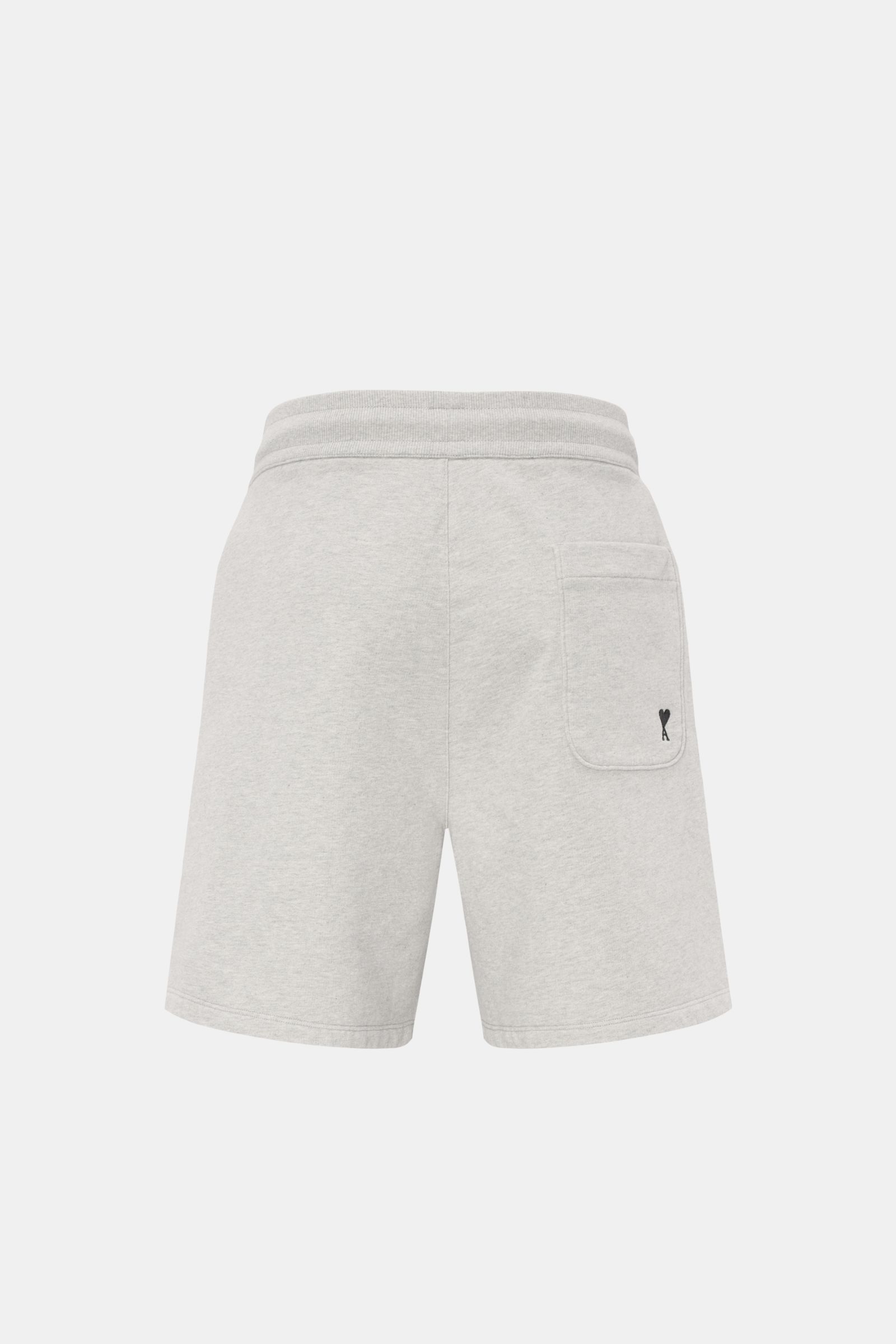 Rear view of Ami Paris Sweat-Bermudas 'Quota' grau meliert in light grey melange, featuring elastic cotton sweat fabric, regular fit, elastic waistband with drawstring, side seam pockets, and a back patch pocket with logo stitching.

Description: Lässi