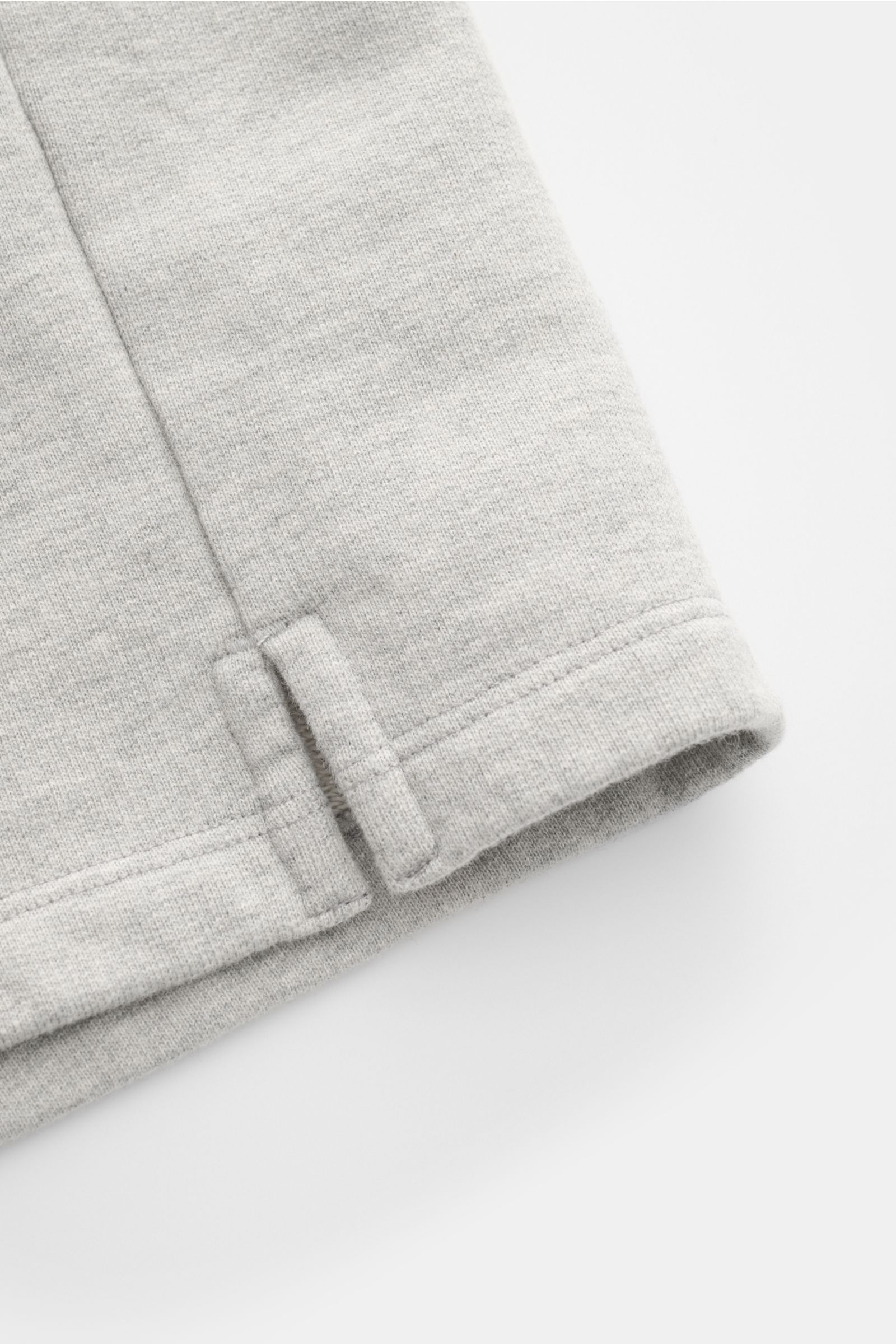 Close-up side view of the Ami Paris Sweat-Bermudas 'Quota' grau meliert showing soft, elastic cotton fabric and detailed hem with stitching. Lässig durch die warme Saison: Die 'Quota' Sweat-Bermudas von AMI PARIS überzeugen mit angenehmen Tragekomfort 