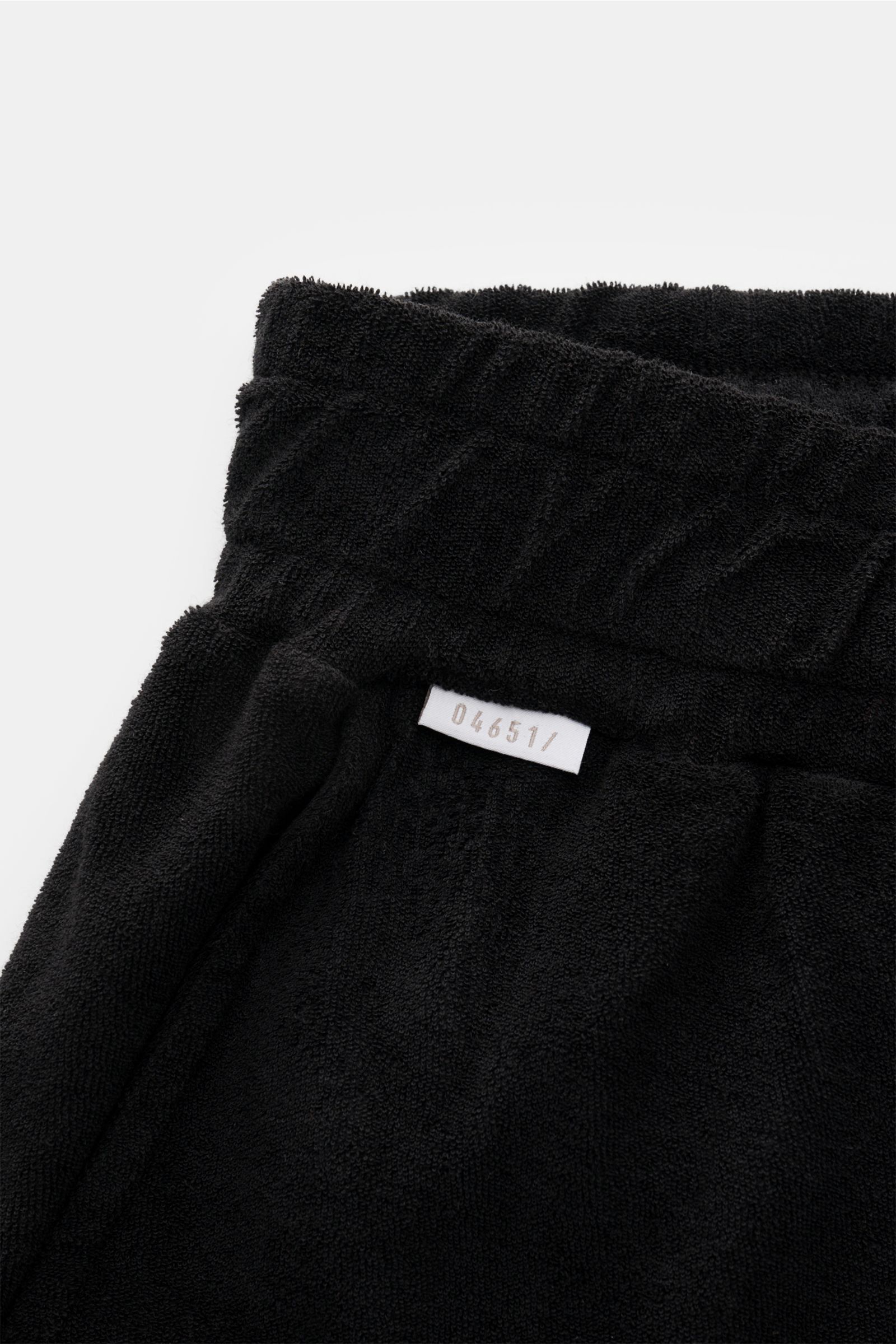 Schwarze 04651/ A trip in a bag Frottee-Shorts 'Terry' aus weichem Baumwoll-Frottee, elastichem Bund mit Tunnelzug, seitlich fotografiert.