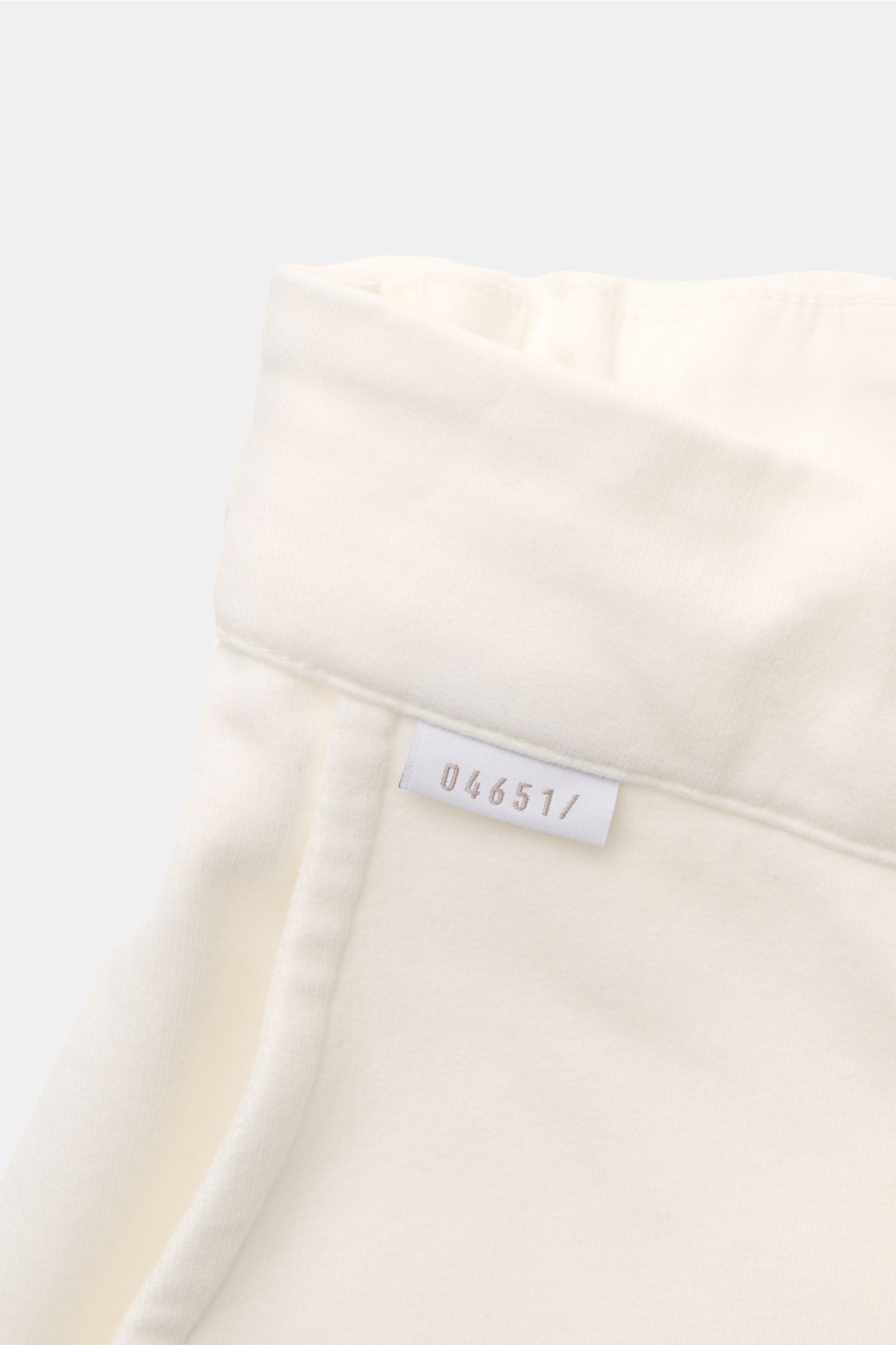 04651/ A trip in a bag Sweat-Shorts offwhite aus Baumwolle, elastischer Bund, weicher Griff, französische Taschen, Detailaufnahme vom Bund mit Label.