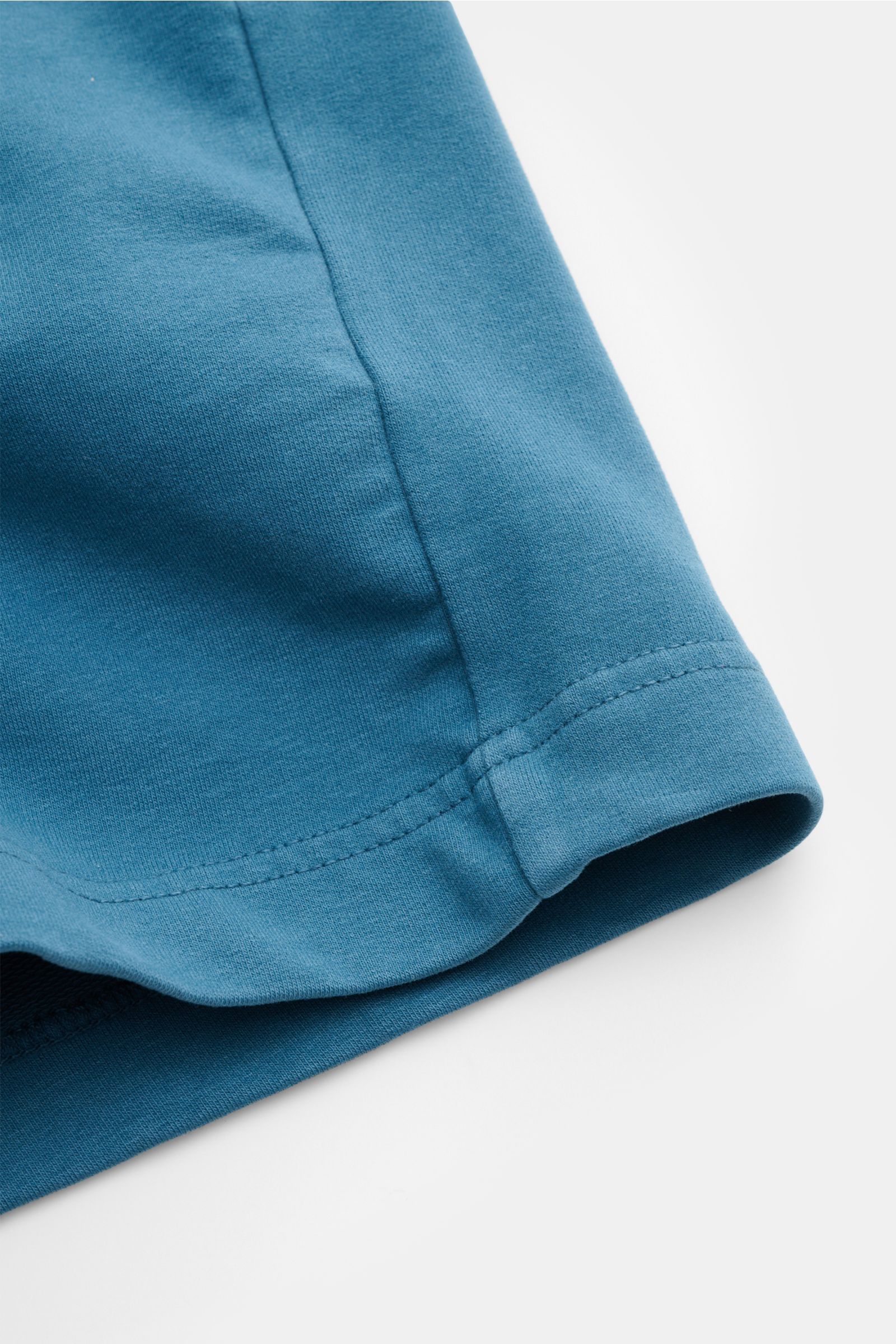 Nahaufnahme der petrolfarbenen 04651/ A trip in a bag Sweat-Shorts aus Baumwolle mit softem Griff, elastischem Bund und sichtbarer Saumnaht.