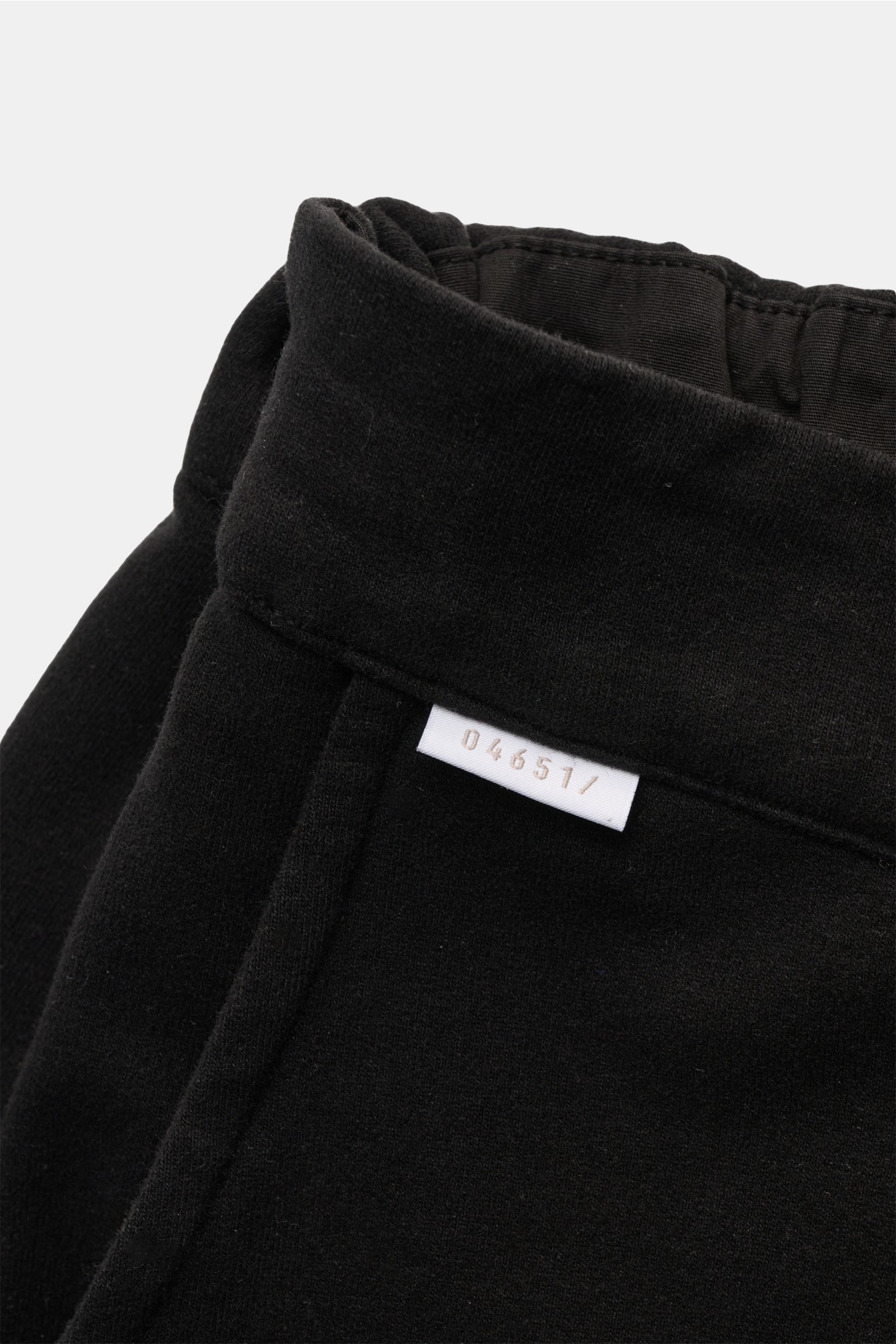 Schwarze 04651/ A trip in a bag Sweat-Shorts aus elastischer Baumwolle, Nahaufnahme seitlich oben mit elastischem Bund und kleinem Weblabel.