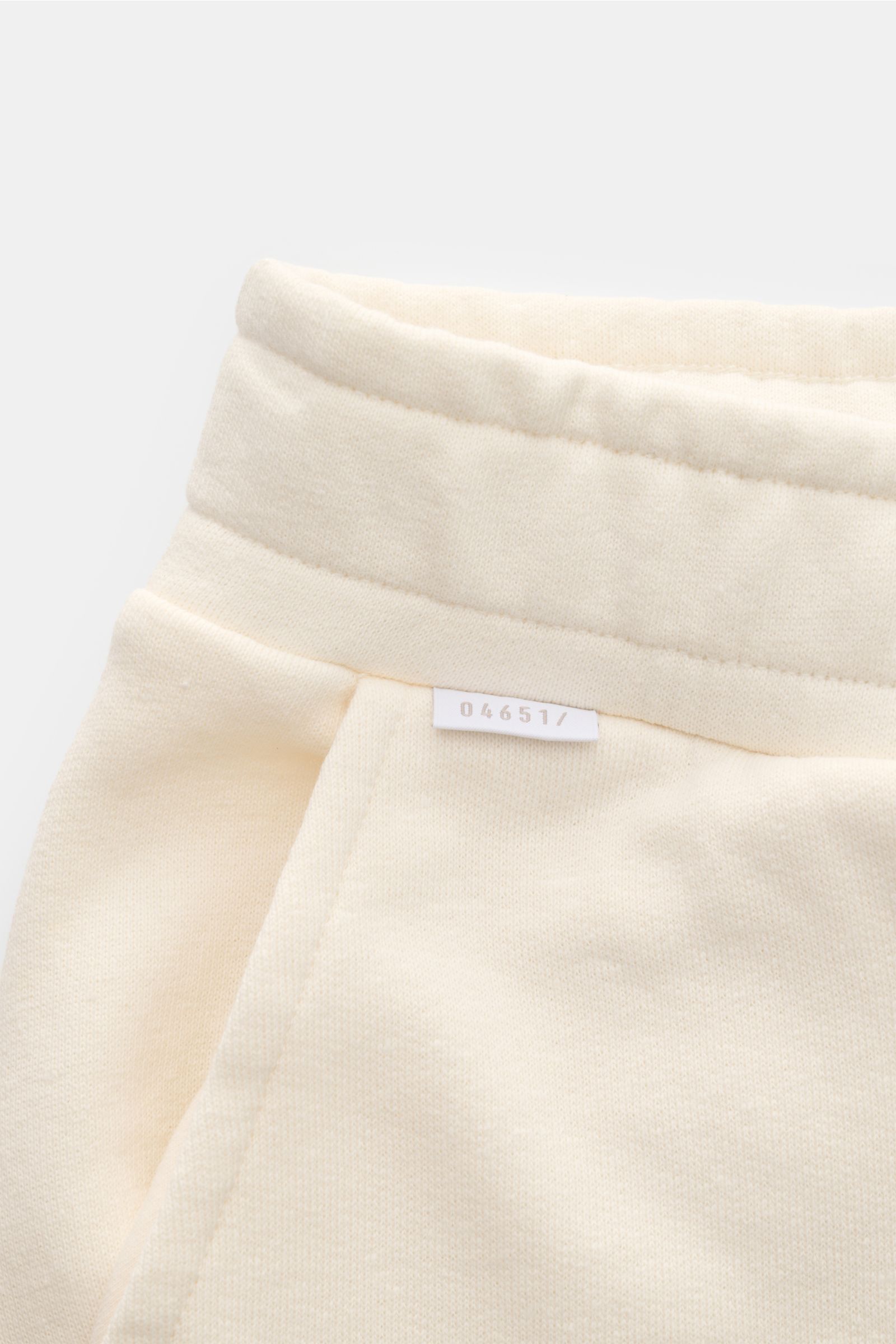 04651/ A trip in a bag Sweat-Shorts 'CL' creme, Nahaufnahme der Taille mit elastischem Bund, Tunnelzug und kleinem Weblabel, Bio-Baumwolle.