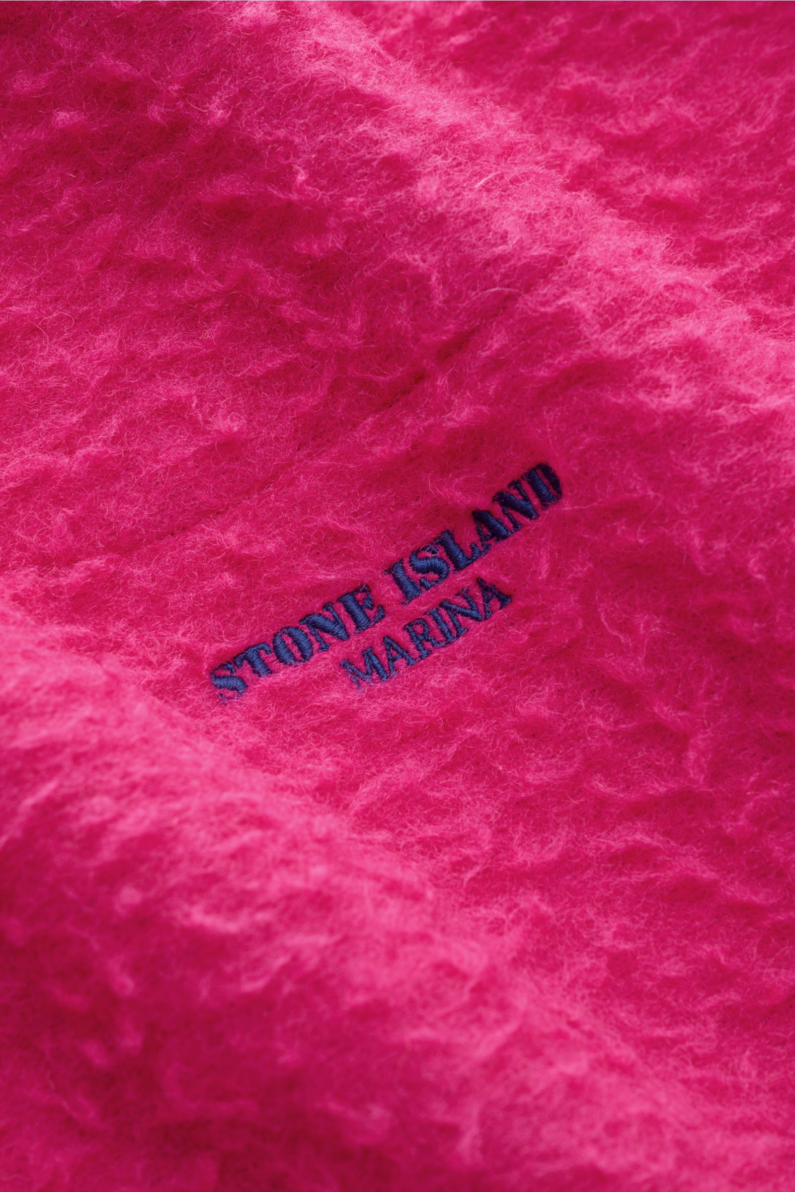 Close-up front view of the textured magenta Stone Island Troyer 'Marina' with embroidered logo on wool-mix fabric.

Description: Extraordinär durch den Herbst: Dieser lässige Troyer aus Woll-Mix in Vintage-Optik von STONE ISLAND mit tiefem Zipper am ho