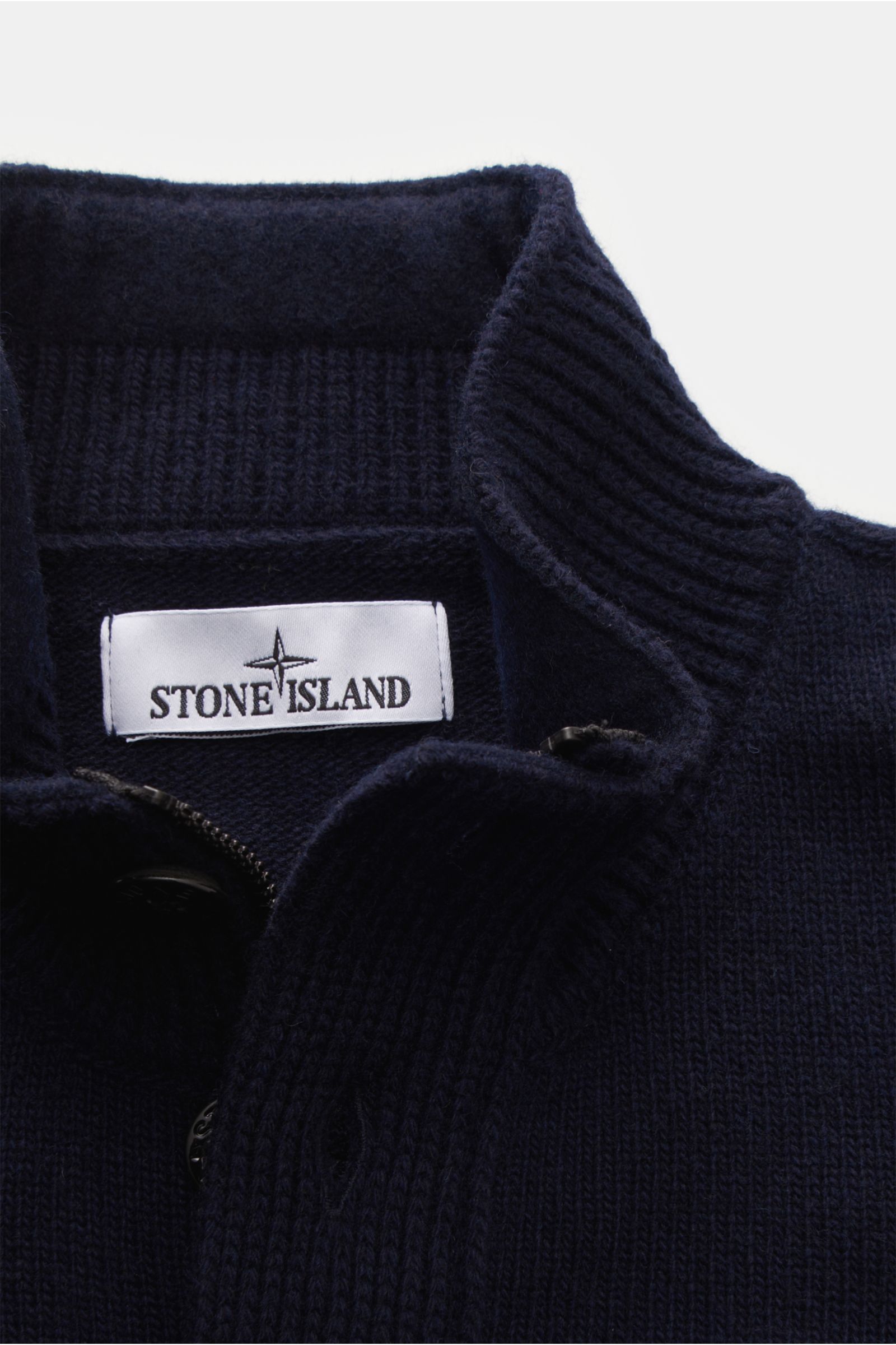 Nahaufnahme von Stone Island Troyer 'Lambswool' navy aus wärmendem Wollmix mit Troyer-Kragen, Zipper und Knöpfen, sichtbares Markenlabel.