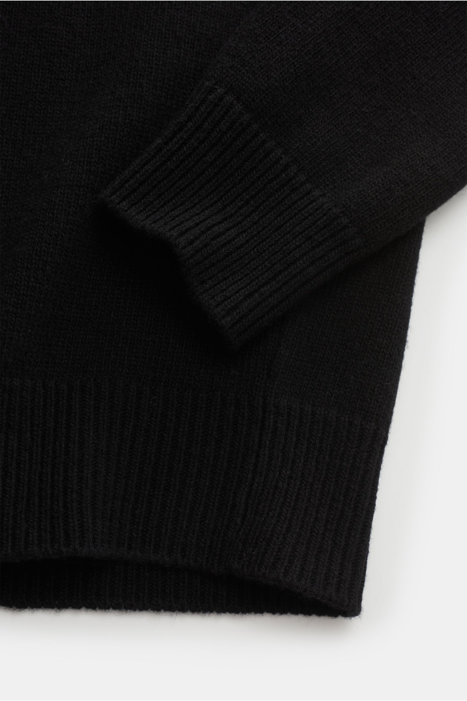 Nahaufnahme des Stone Island Troyer 'Lambswool' schwarz, gestrickt aus Wollmix mit elastischen Rippbündchen, Slim Fit, Troyer-Kragen mit Zipper.
