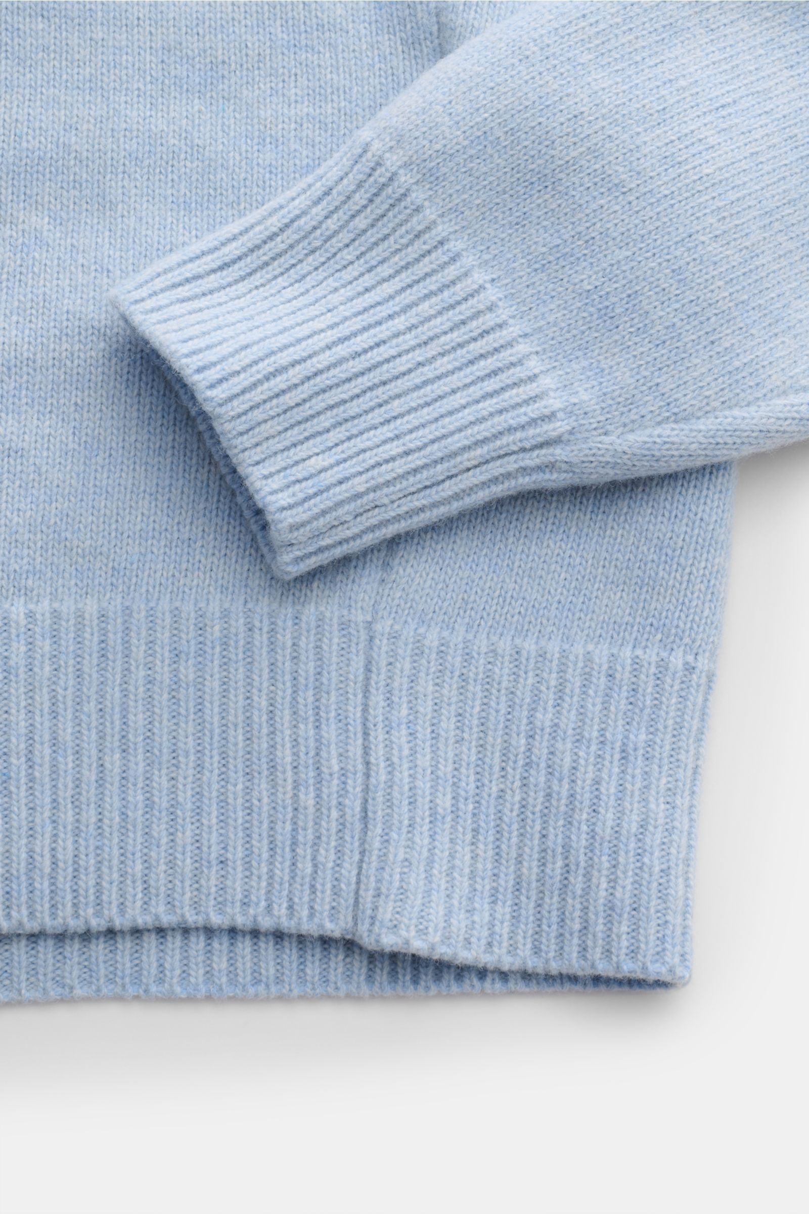 Stone Island Half-zip jumper 'Lambswool' light blue shown from a close-up side angle, highlighting ribbed cuffs and hem. A stylish essential for the colder months: This timeless half-zip jumper by STONE ISLAND with zip and embossed buttons on the colla