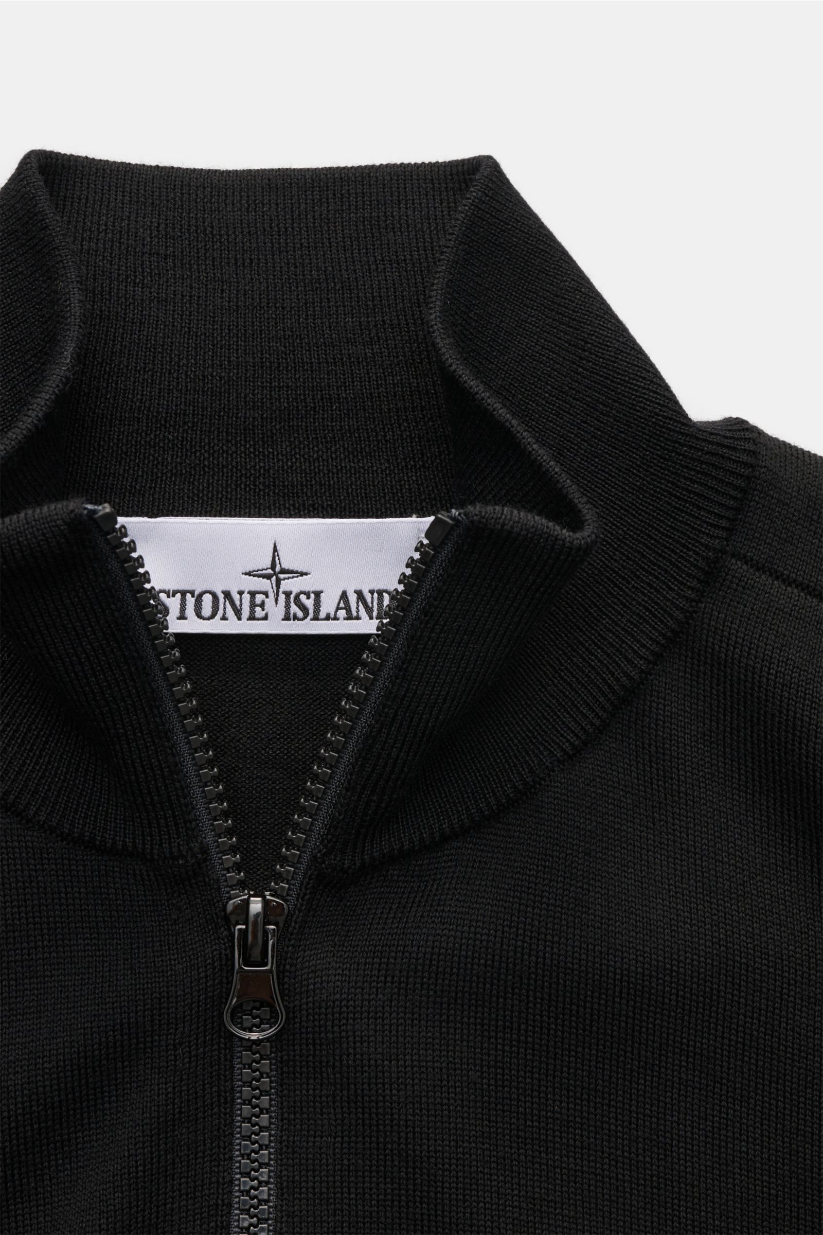 Close-up front view of Stone Island Troyer 'Light Pure Wool' schwarz in black, featuring a slim fit, ribbed zip collar, and fine wool knit.

Ein Strickklassiker mit zeitloser Ausstrahlung: Dieser Troyer von STONE ISLAND steht mit feiner Schurwolle, sch