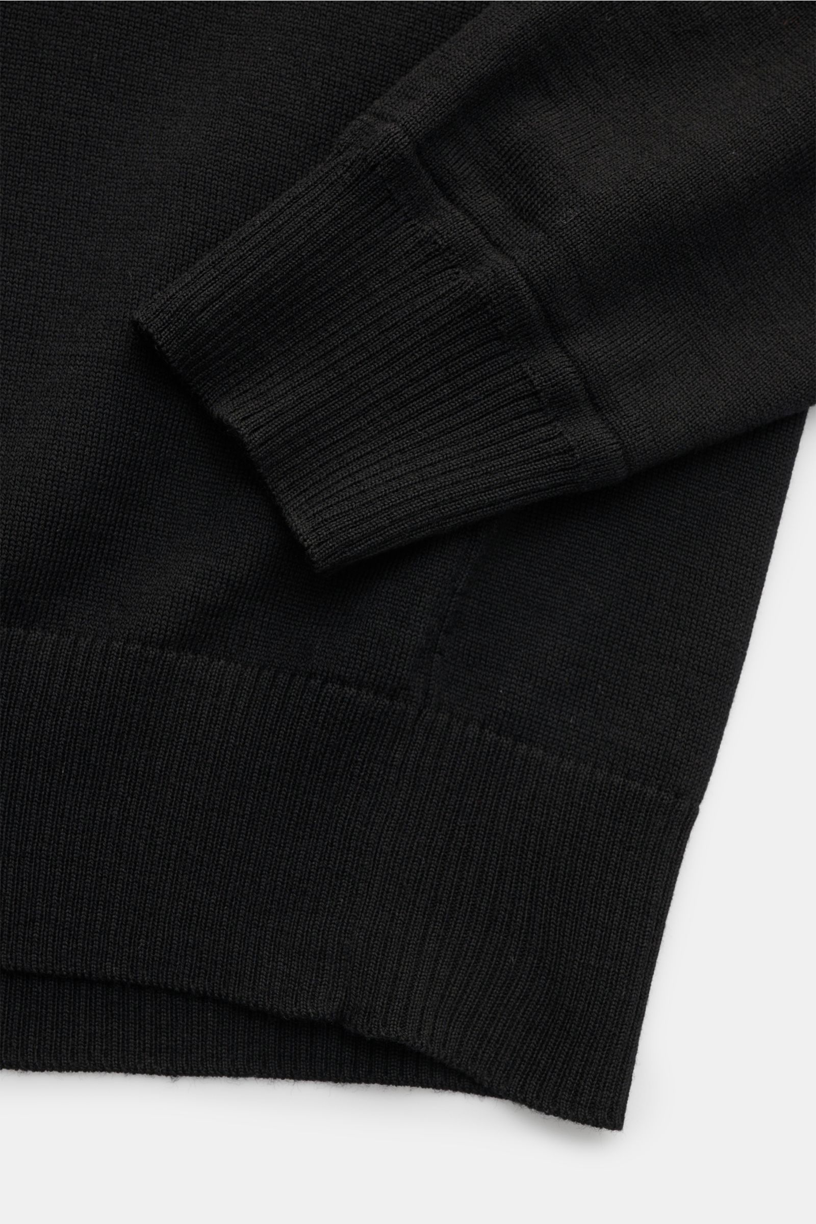 Stone Island Troyer 'Light Pure Wool' schwarz shown from a close-up side view, highlighting ribbed cuffs and hem of fine black pure wool knit.

Ein Strickklassiker mit zeitloser Ausstrahlung: Dieser Troyer von STONE ISLAND steht mit feiner Schurwolle, 