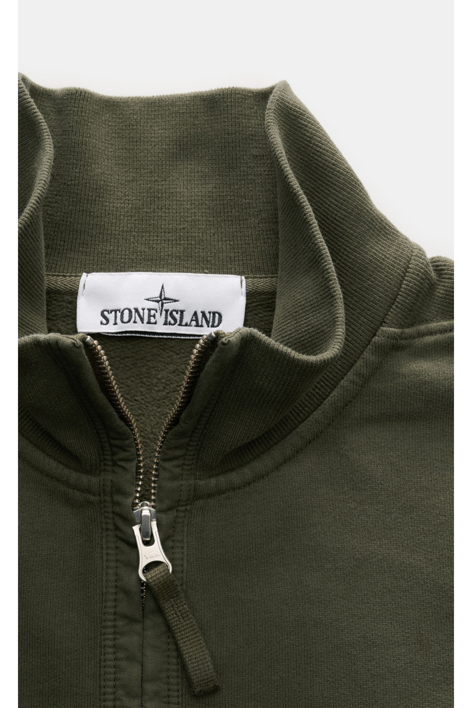 Nahaufnahme des hochschließenden Kragens mit Zipper eines olivgrünen Stone Island Sweat-Troyers aus weicher Baumwolle mit Rippstrick.