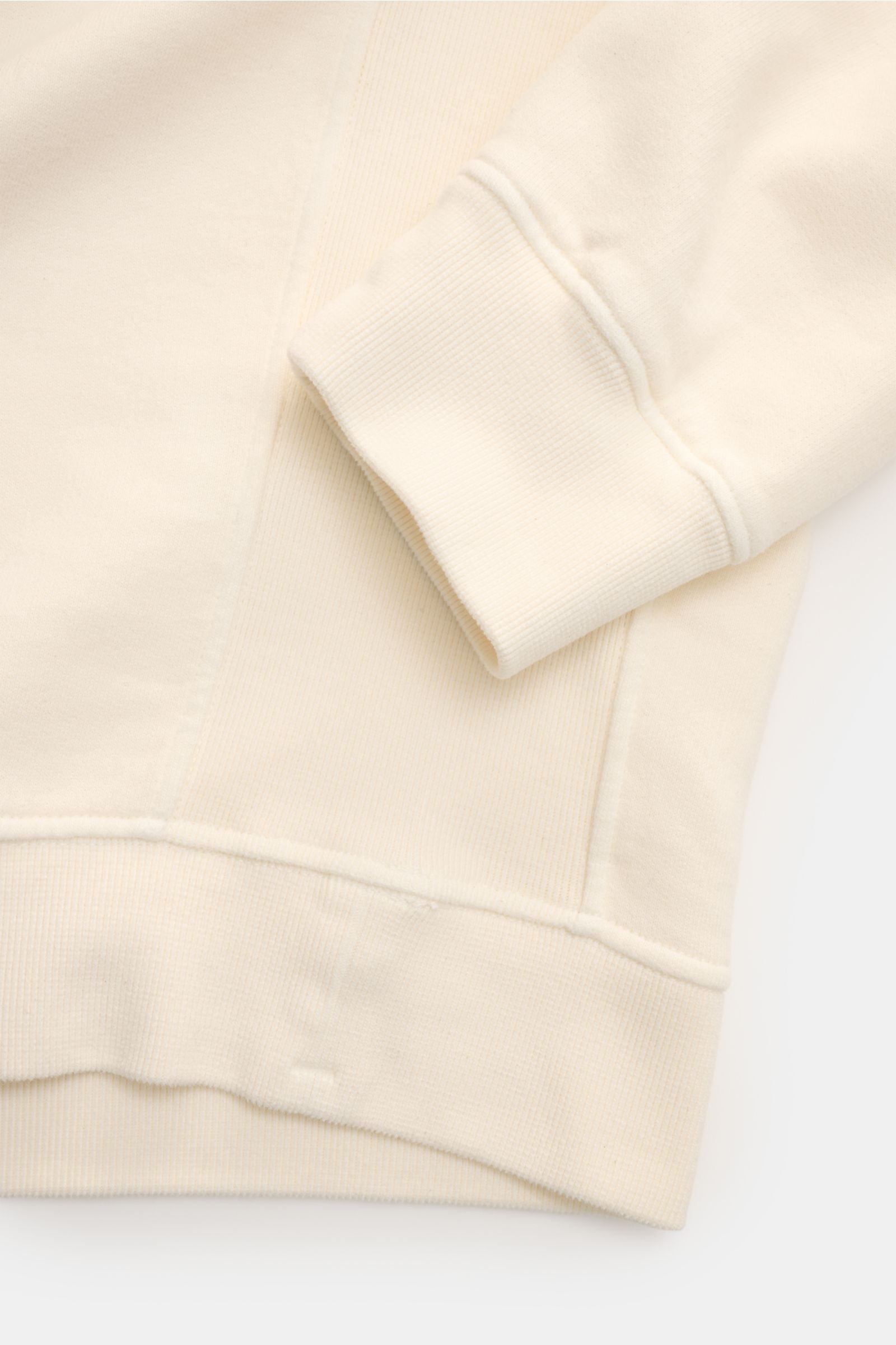 Stone Island Sweat-Troyer creme, Detailaufnahme von Ärmel und Bund, weiche Baumwolle, Rippstrick-Einsätze, Kompass-Badge am Oberarm.
