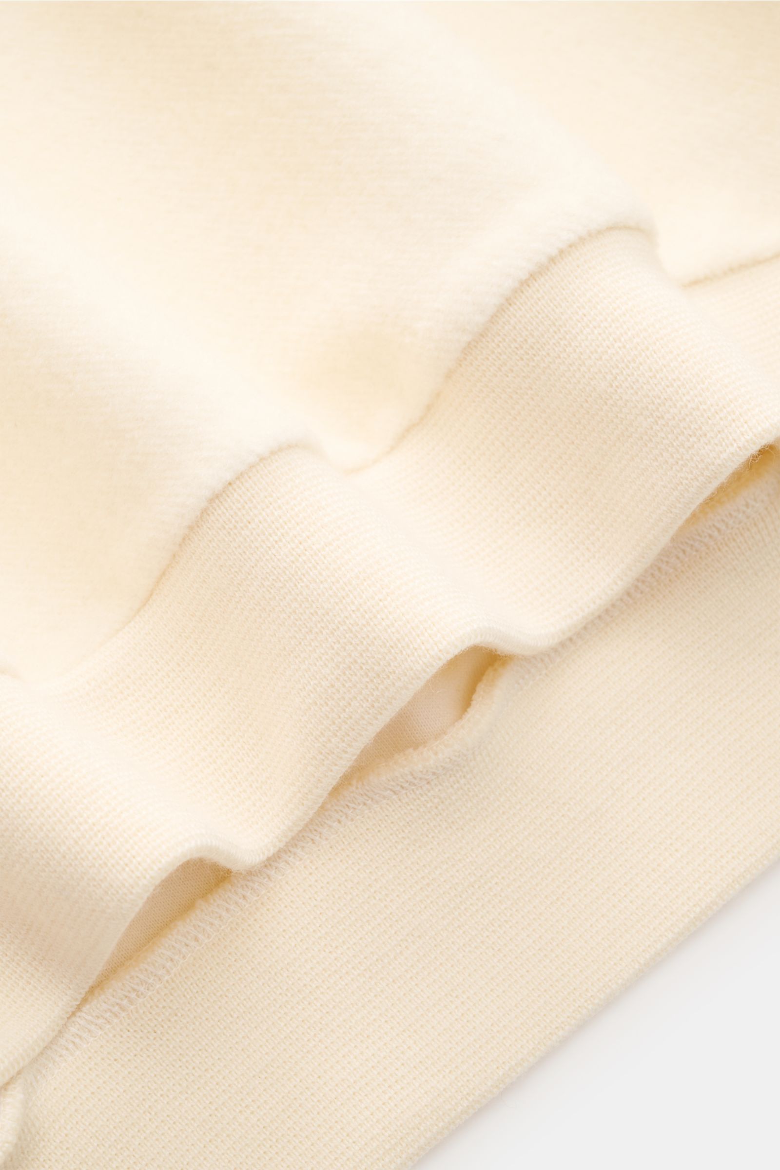 Close-up side view of the 04651/ A trip in a bag Troyer 'Cw Quarter Zip' creme showing its soft fleece texture and ribbed cuff. Lässig durch die Übergangszeit: Der Troyer von 04651/ A TRIP IN A BAG überzeugt mit seiner samtigen Fleece-Textur aus natürlich