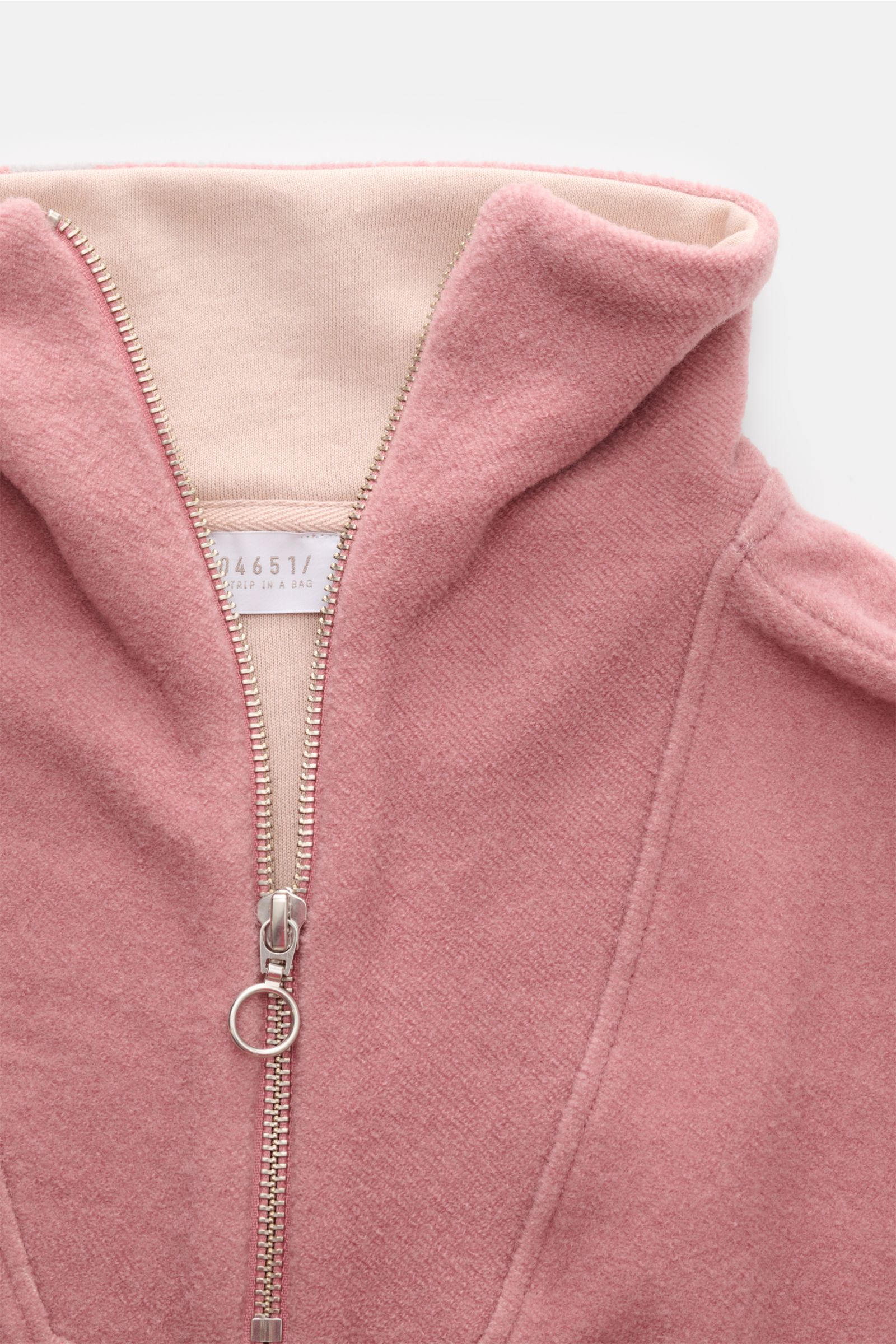 Close-up front view of the 04651/ A trip in a bag Troyer 'Cw Quarter Zip' altrosa, showing its soft, pink fleece texture and silver zipper. Lässig durch die Übergangszeit: Der Troyer von 04651/ A TRIP IN A BAG überzeugt mit seiner samtigen Fleece-Textur a