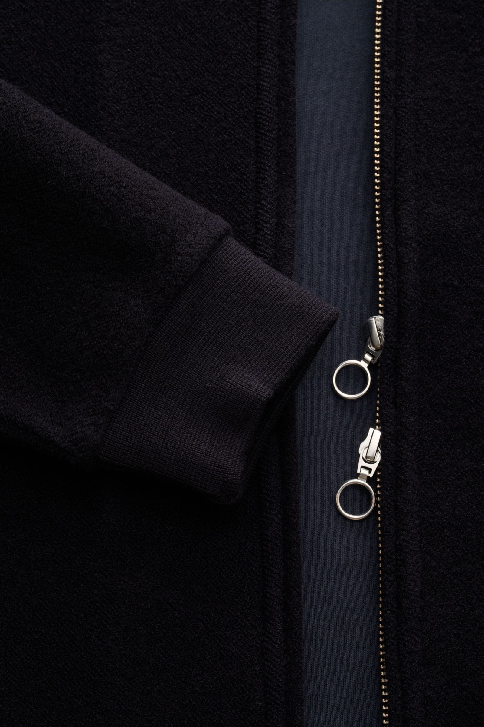 Nahaufnahme des navyfarbenen 04651/ A trip in a bag Blouson, seitlich fotografiert, mit samtiger Fleece-Textur, Rippbündchen und zwei-Wege-Reißverschluss.