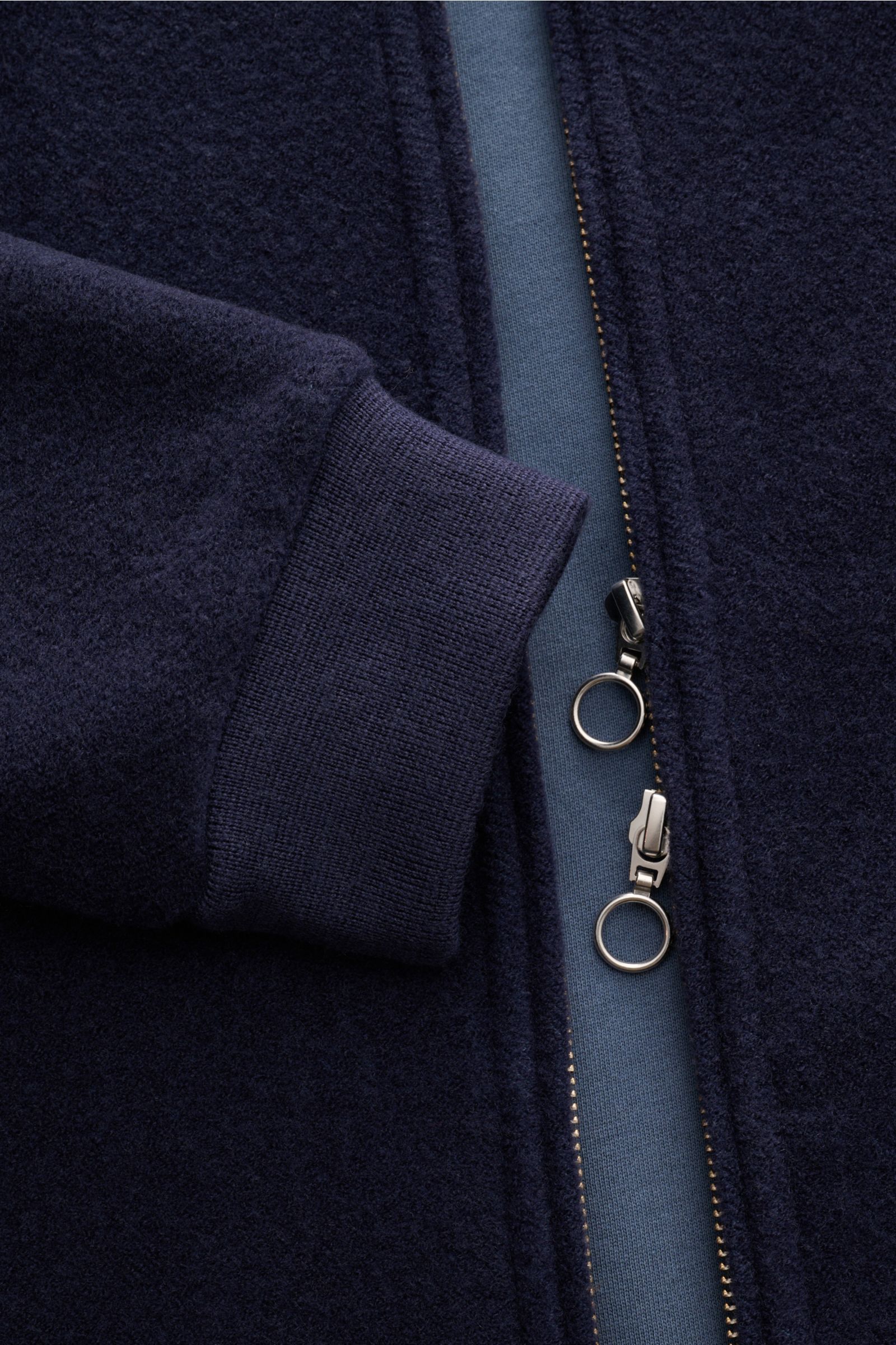 Close-up front view of the 04651/ A trip in a bag Blouson dunkelblau showing dark blue wool-cotton fleece texture, ribbed cuff, and two-way zipper with ring pulls.