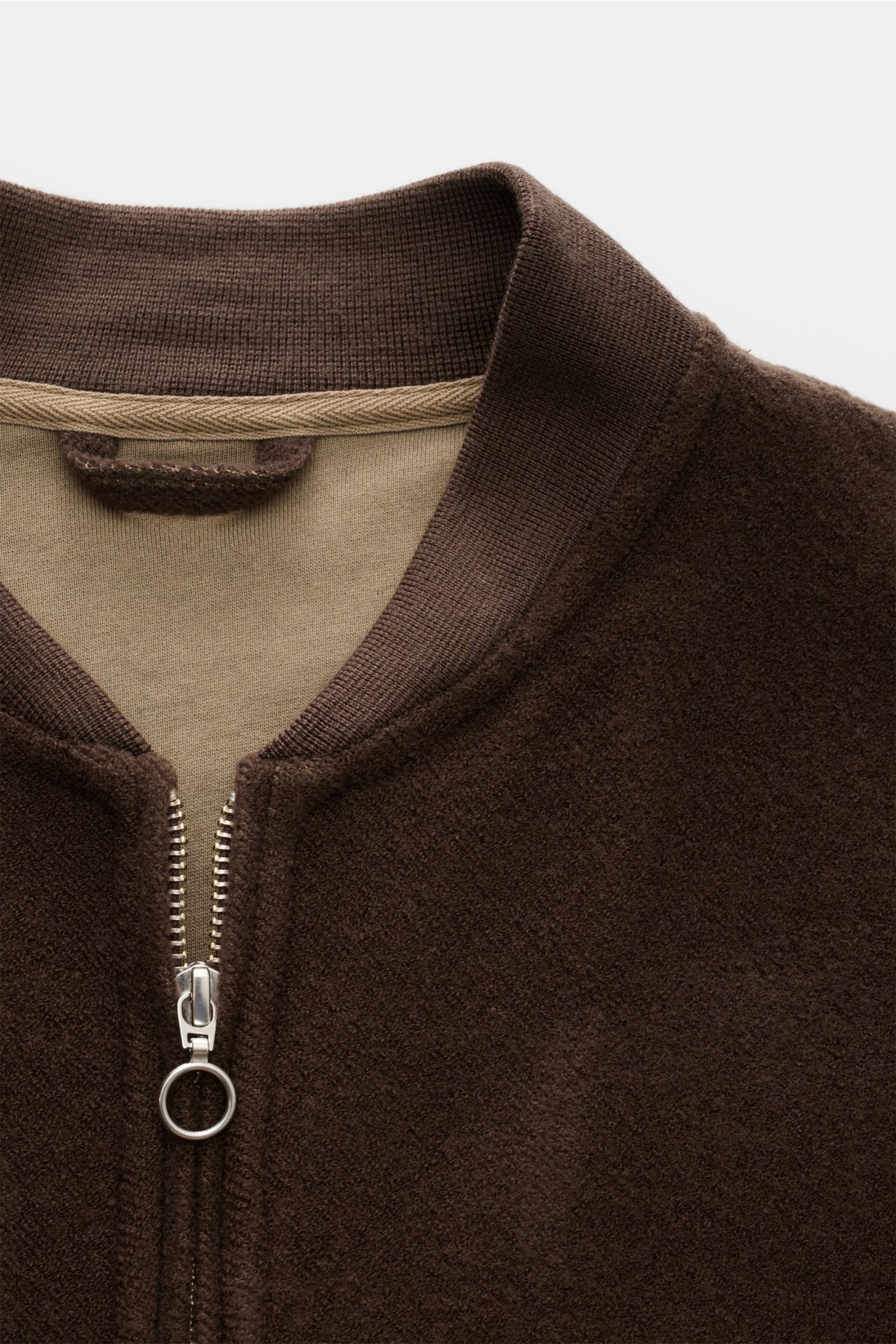 Nahaufnahme des Kragens und Zwei-Wege-Reißverschlusses des dunkelbraunen 04651/ A trip in a bag Blouson aus Wolle-Baumwollmix mit samtiger Fleece-Textur, Slim Fit und Rippstrickblousonkragen, fotografiert von vorne oben.