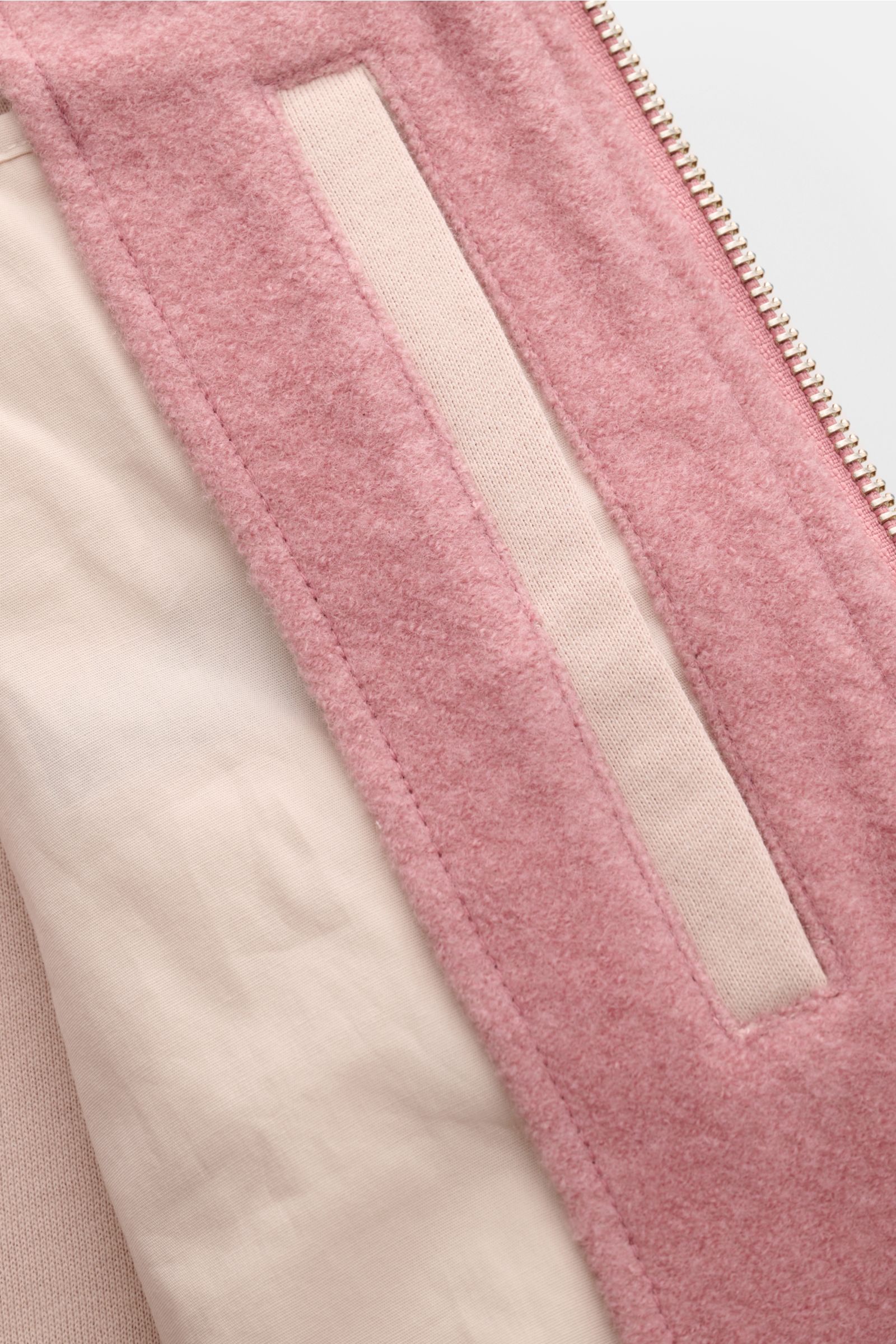 Close-up view of the 04651/ A trip in a bag Blouson altrosa showing its soft pink fleece texture, side welt pocket, and inside lining. Lässig durch die Übergangszeit: Der Blouson von 04651/ A TRIP IN A BAG überzeugt mit seiner samtigen Fleece-Textur aus n