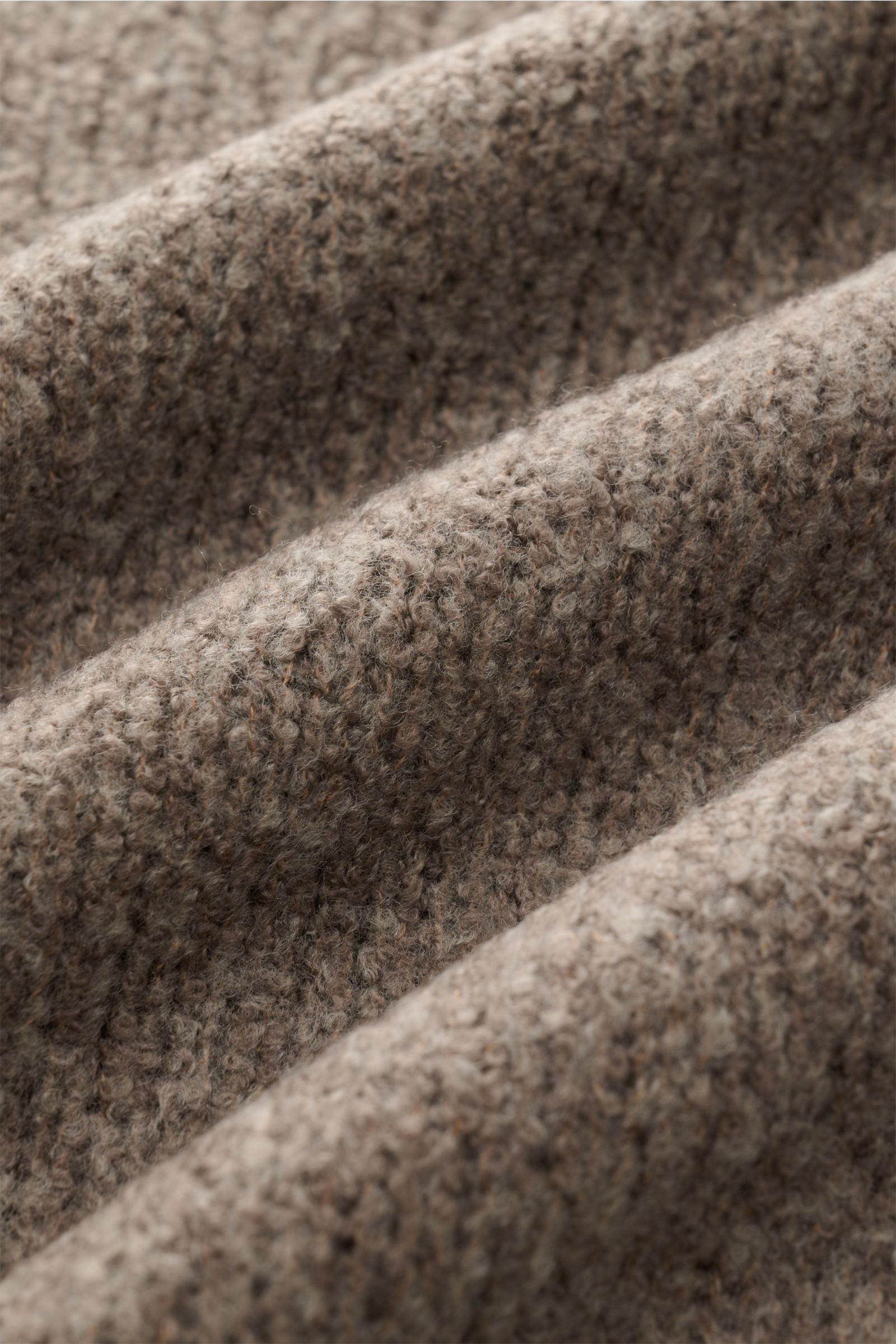 Nahaufnahme des taupefarbenen Boucléstricks mit mittelfeinem Strickbild des 04651/ A trip in a bag Troyer 'Grainy' taupe, Mix aus Wolle und Microfaser, weicher Griff, Regular Fit, hoher Rippstrickkragen mit Zipper und breiten Rippbündchen.