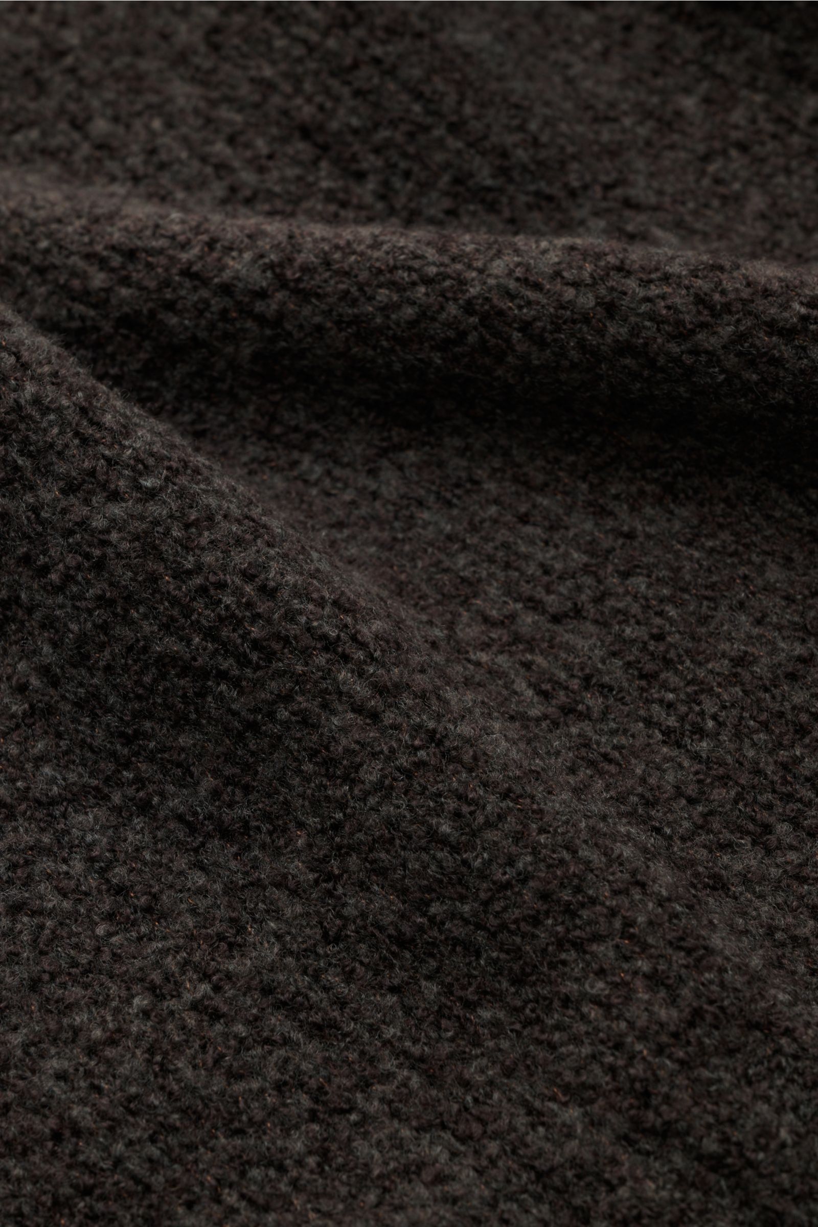 Nahaufnahme des Boucléstricks mit mittelfeinem Strickbild des graubraunen 04651/ A trip in a bag Troyer 'Grainy', Mix aus Wolle und Microfaser, weicher Griff.