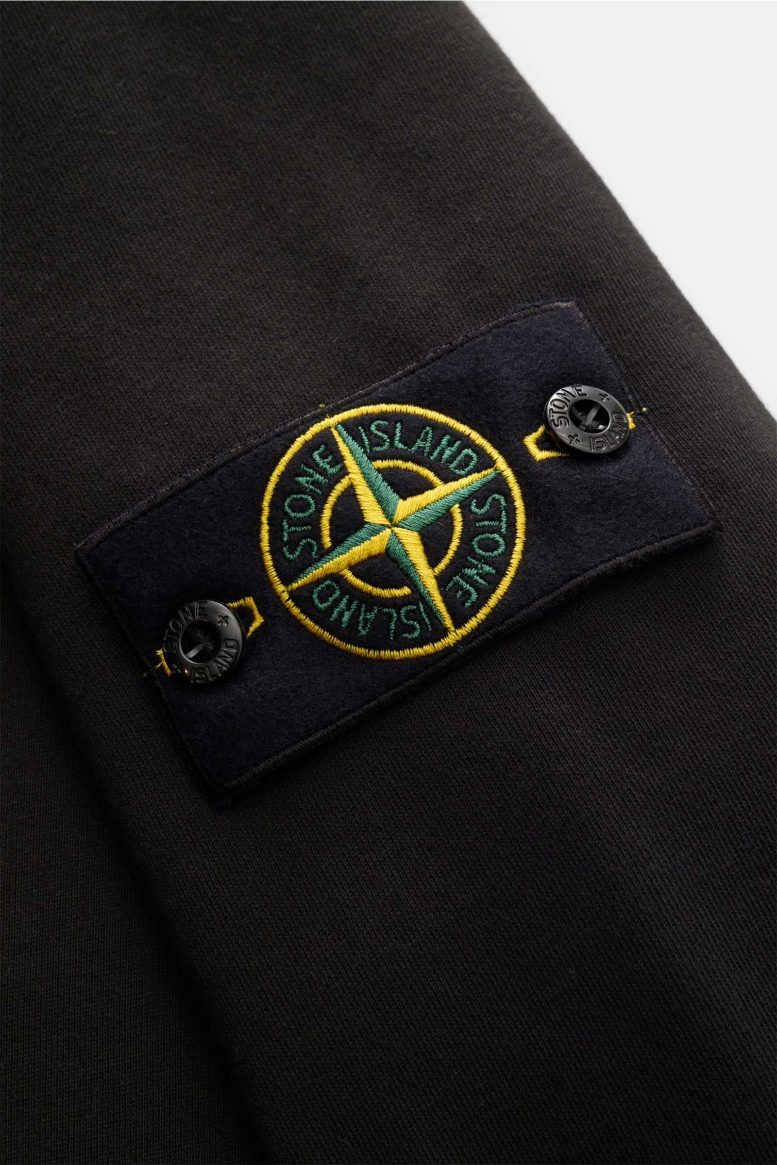 Close-up of the Stone Island Sweat-Troyer 'Basic Sweat' schwarz sleeve showing the compass badge from a side angle.

Sportives Essential: Der Sweat-Troyer von STONE ISLAND überzeugt als legeres Basic Piece und wird zum unverzichtbaren Begleiter für urb