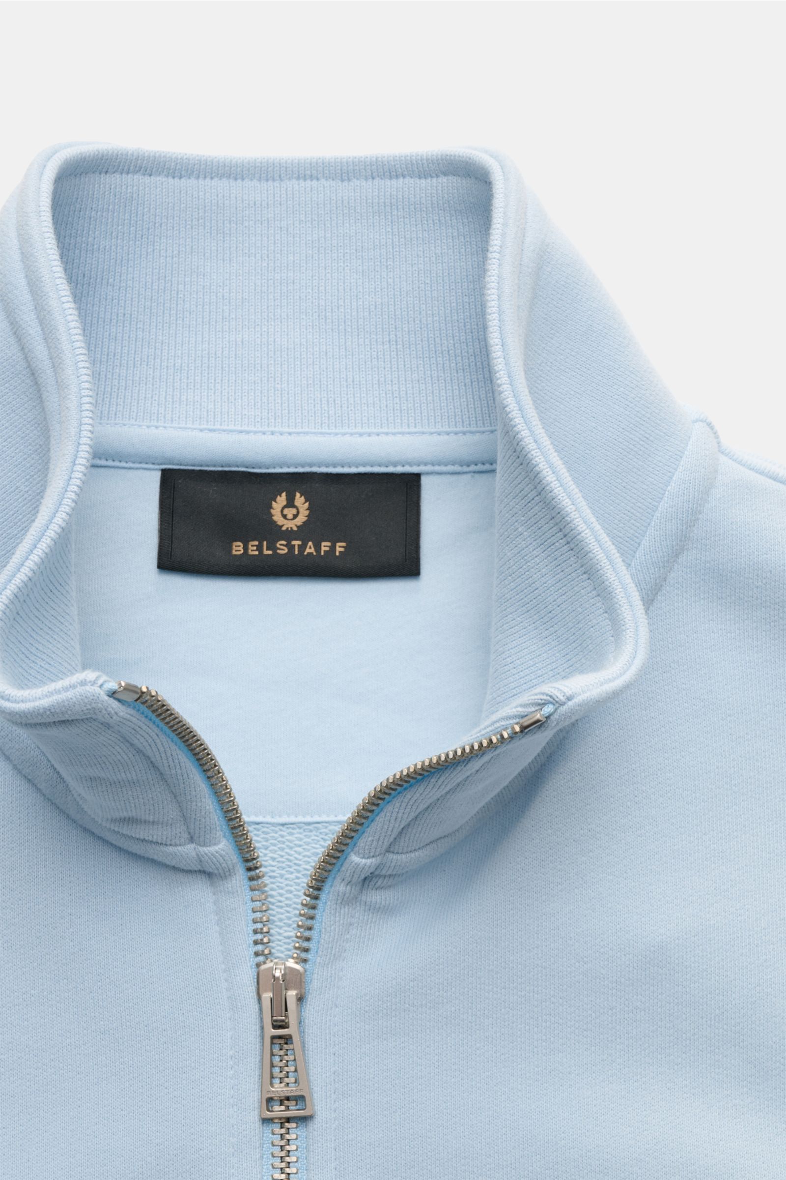 Belstaff Sweat-Troyer 'Quarter Zip' hellblau aus reiner Baumwolle, weicher Griff, Slim Fit, Troyer-Kragen mit Reißverschluss, Weblabel, flexible Bündchen, Nahaufnahme von oben.