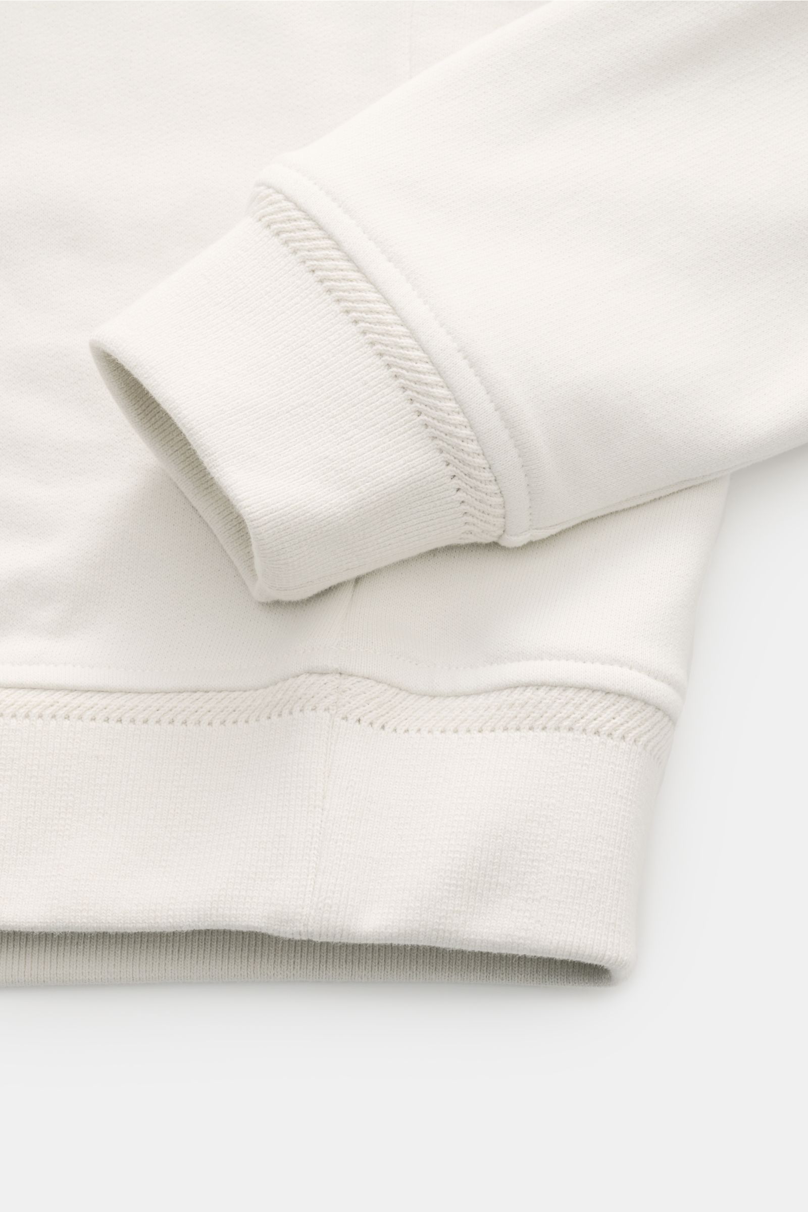 Nahaufnahme des cremefarbenen Belstaff Sweat-Troyer 'Quarter Zip', Fokus auf weichen Baumwollstoff, Slim Fit Ärmelbündchen und Saum.