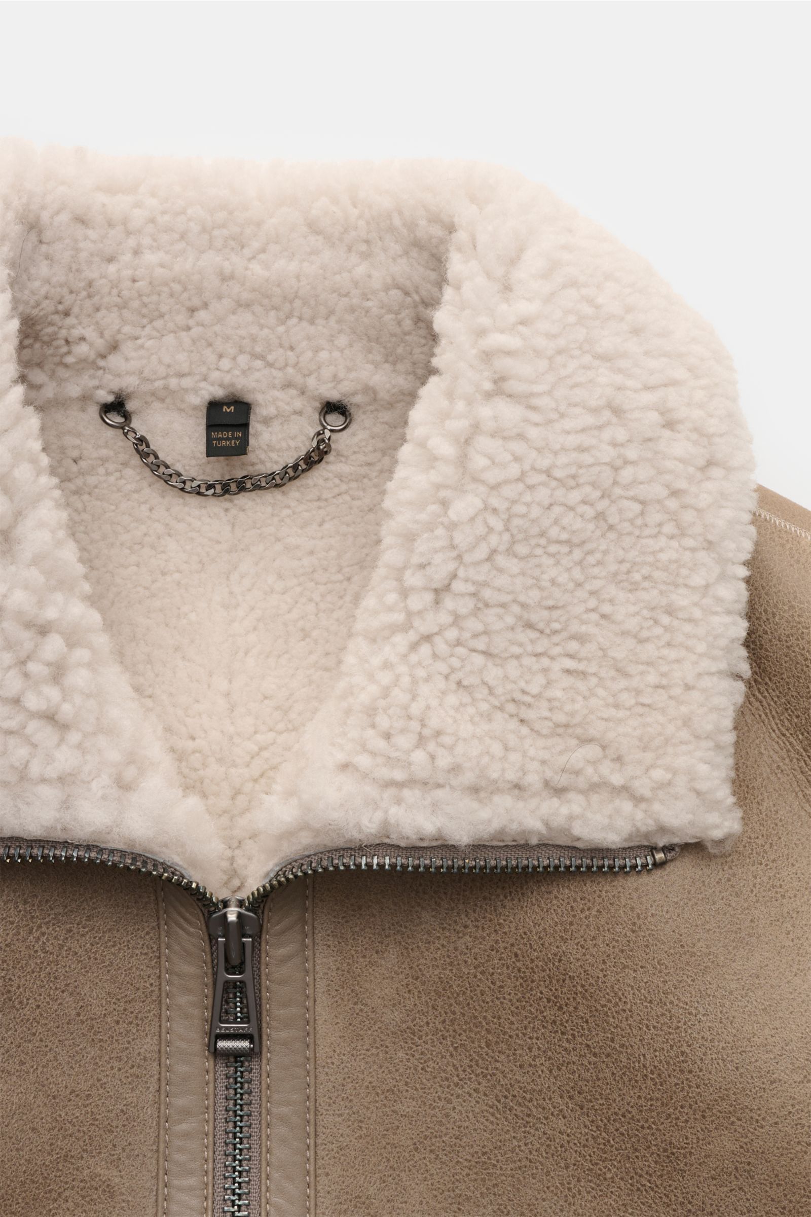 Belstaff Lammfell-Blouson 'Trace' khaki shown from a close-up front perspective, highlighting the soft cream shearling collar, robust zipper, and textured half-oiled premium lamb leather. Der Lammfellblouson 'Trace' von BELSTAFF vereint authentisches D